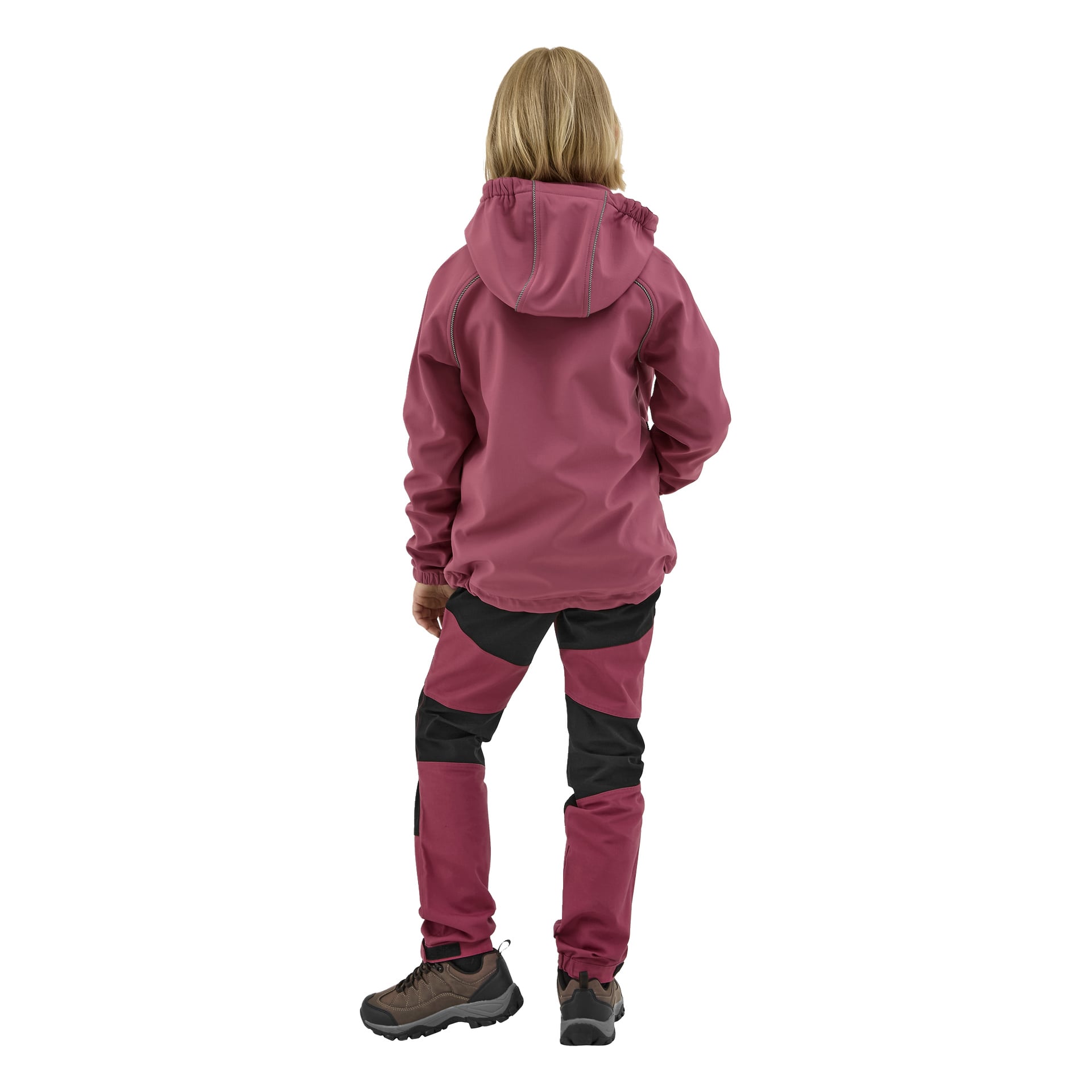 Lapsi, jolla on olkapäille ulottuvat vaaleat hiukset, nähtynä takaapäin, on pukeutunut viininpunaiseen Kayoba Outdoor Children's Softshell Jacket Kramforsiin, huppuun, yhteensopiviin viininpunaisiin ja mustiin housuihin sekä ruskeisiin ja mustiin vaelluskengiin.