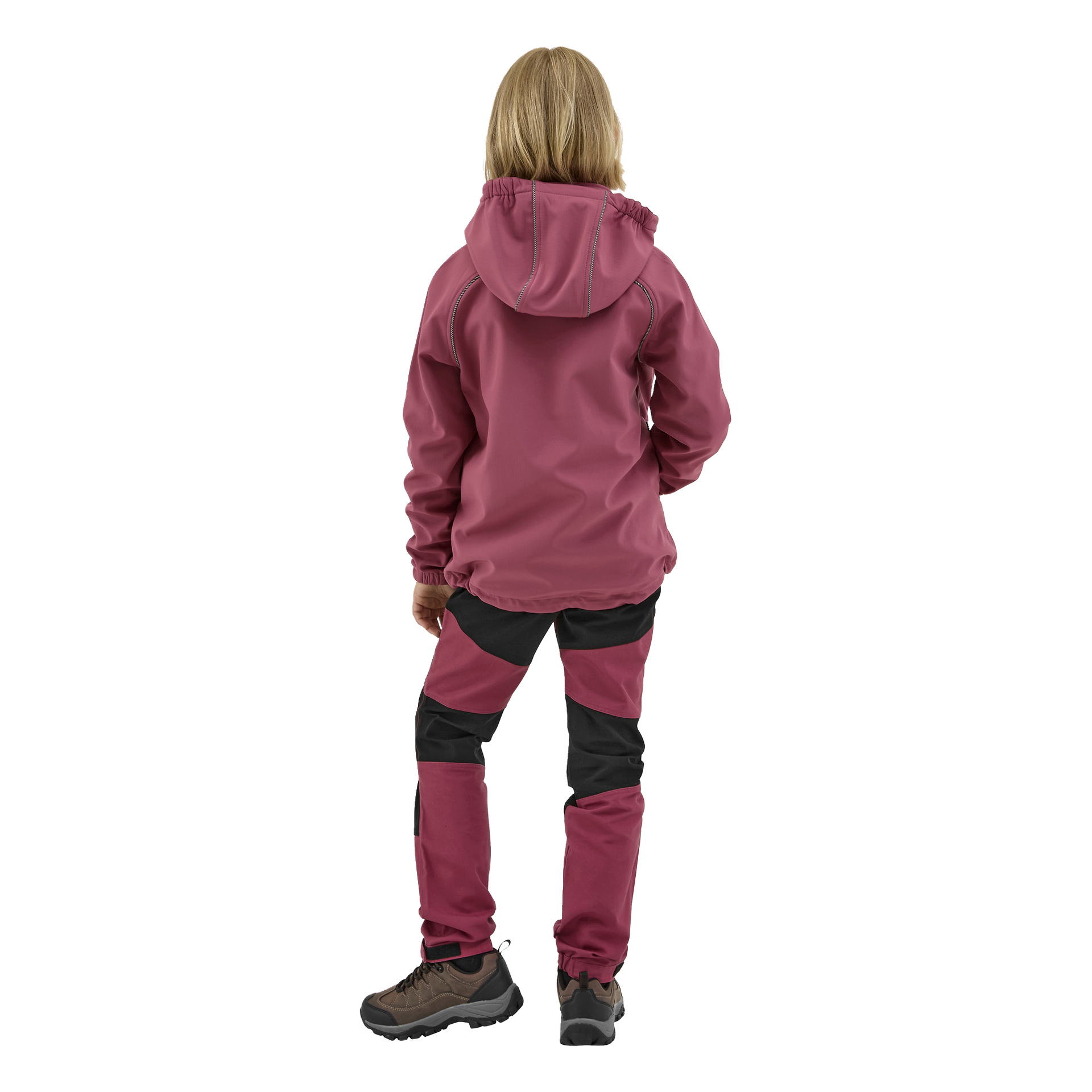 Vaaleahiuksinen lapsi katsoo poispäin, pukeutuneena viininpunaiseen Kayoba Outdoor Children's Kramfors -softshell-takkiin, jossa on huppu ja yhteensopivat viininpunaiset ja mustat housut sekä ruskeat vaelluskengät.