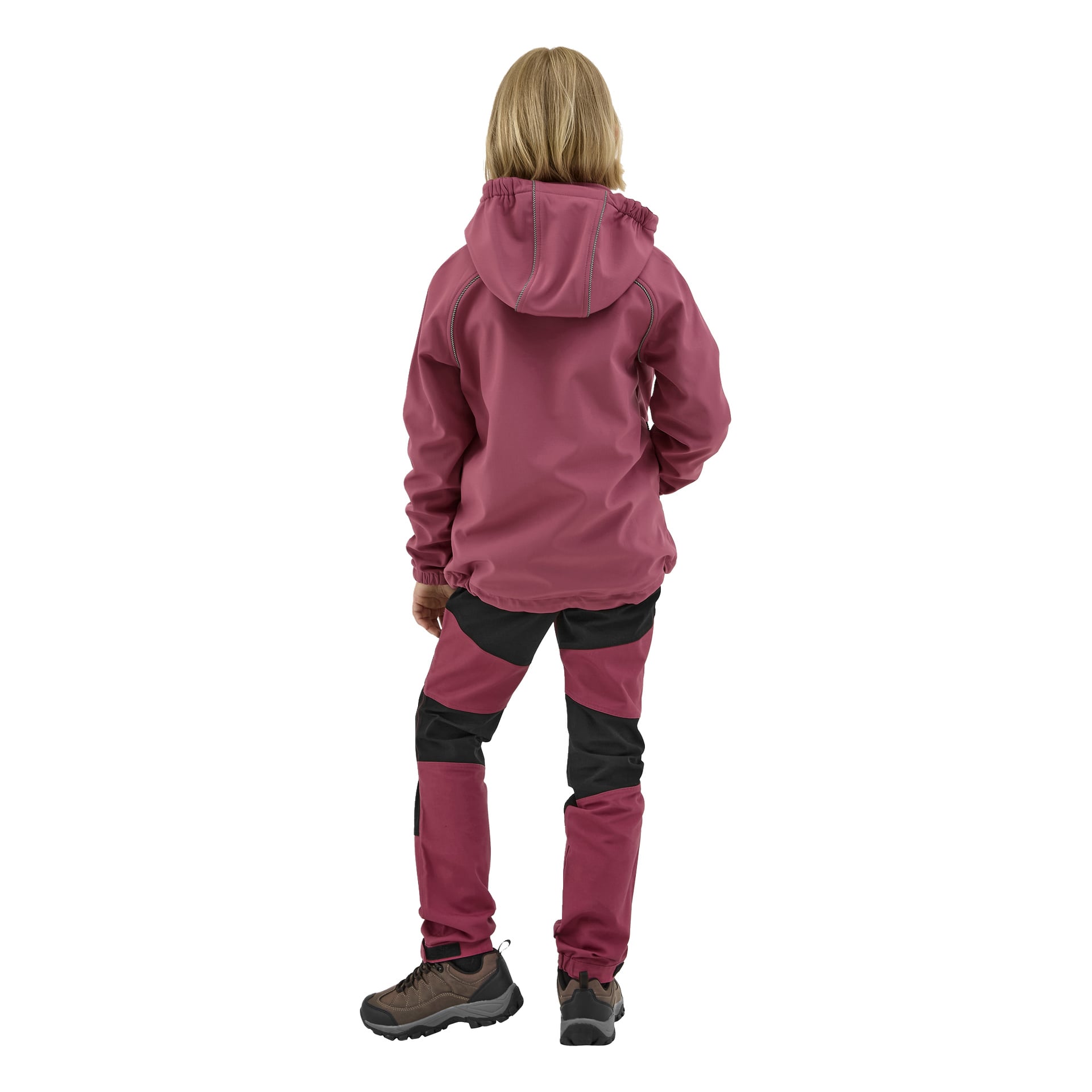 Lapsi, jolla on olkapäille ulottuvat vaaleat hiukset, seisoo selin poispäin, pukeutuneena Kayoba Outdoor Children's softshell -takkiin Kramfors mauve-mustana sekä yhteensopiviin housuihin ja vaelluskengiin.