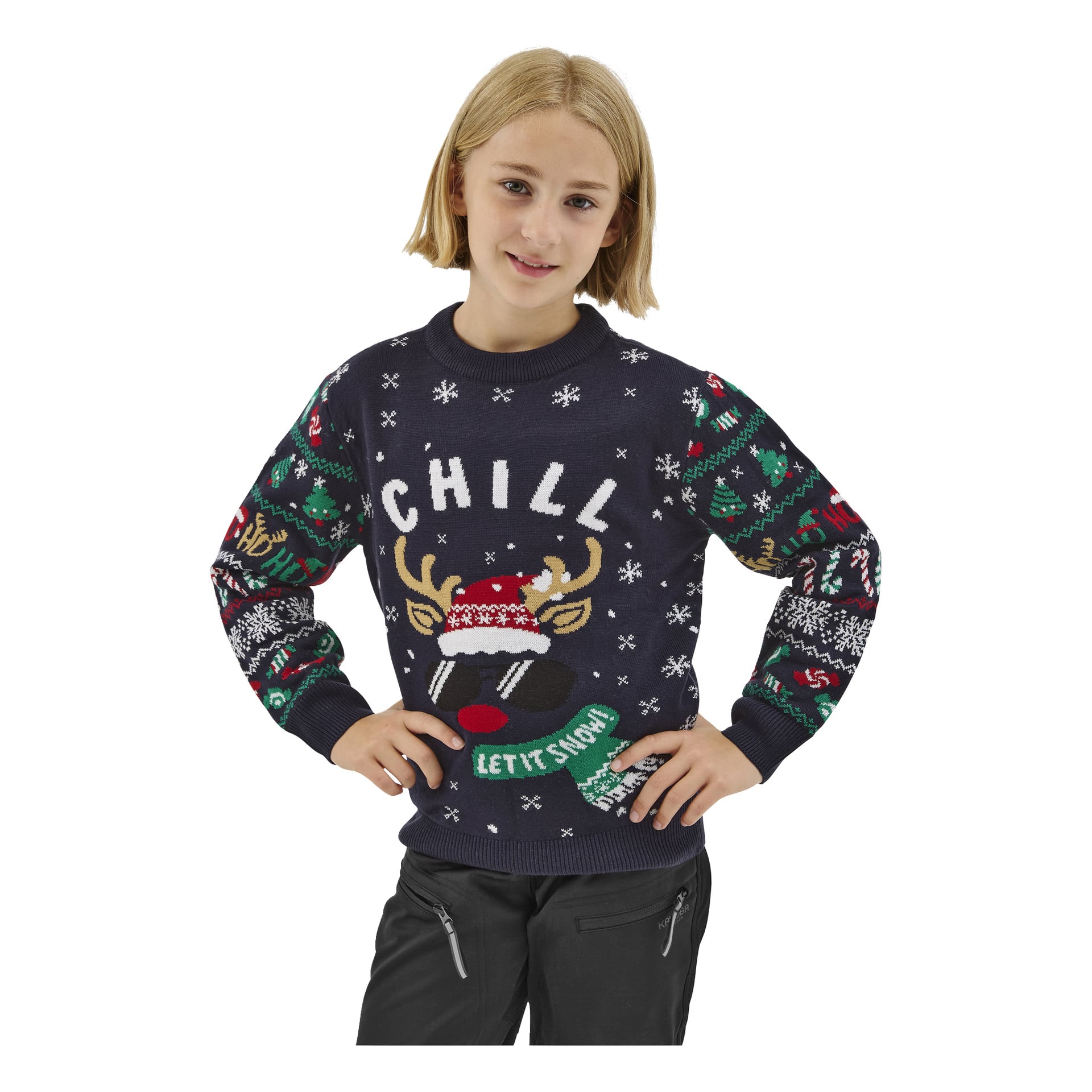 En ung person med axellångt blont hår bär en Bluewear Children's jultröja med renhorn, snöflingor och orden "CHILL" och "LET IT SNOW." De ler och har händerna i sidan.
