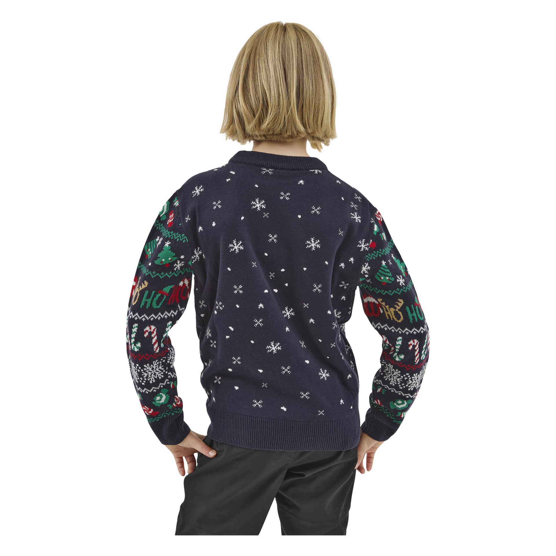 Ett blont barn står med ryggen mot betraktaren, händerna på höfterna, klädd i en mörk Bluewear Children's jultröja dekorerad med snöflingor, julgranar, polkagrisar och "Ho Ho Ho" längs ärmarna.