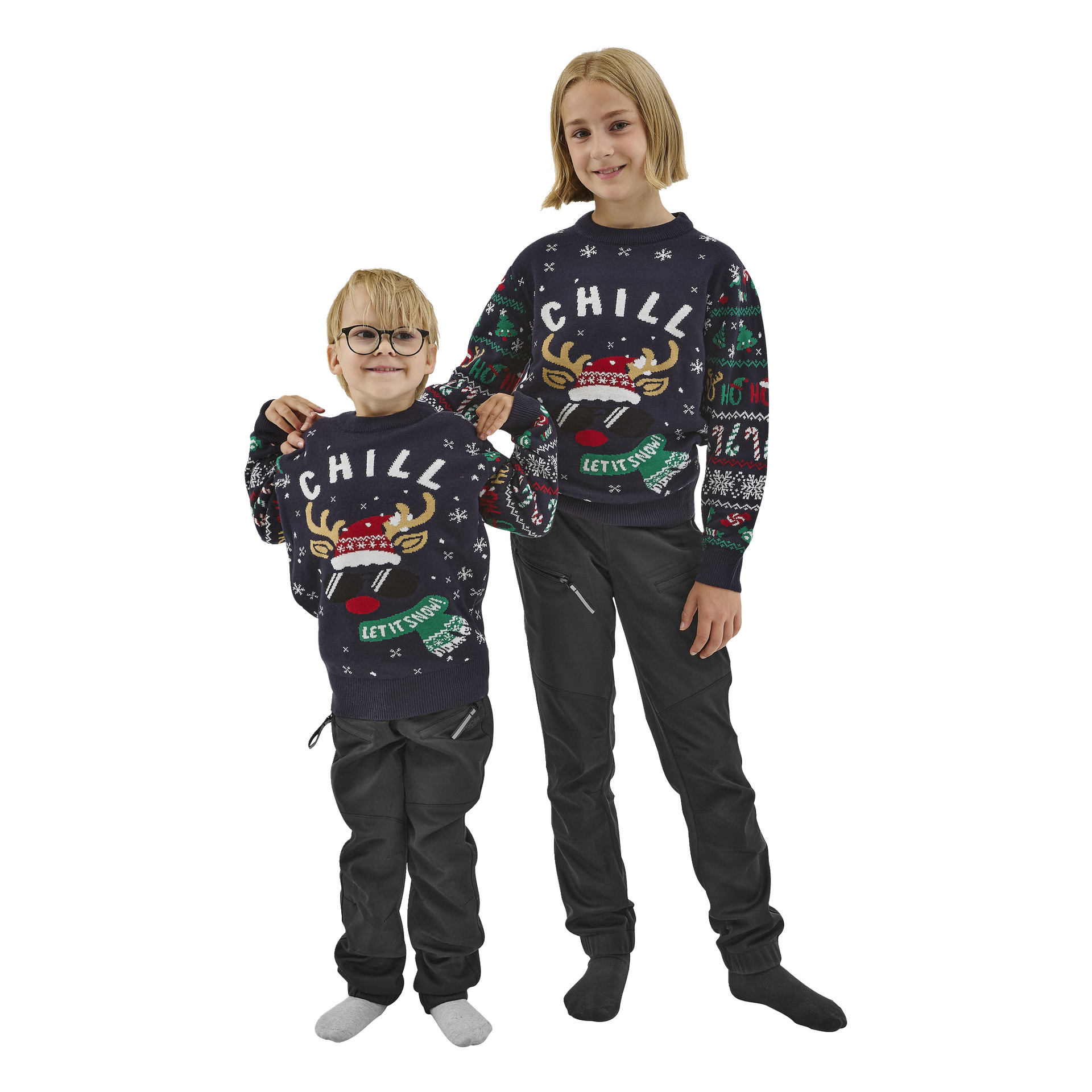 Två leende barn står bredvid varandra, båda iförda Bluewear Children's jultröjor. Tröjorna är mörka med en ren och ordet "CHILL" på framsidan, tillsammans med mörka byxor. Båda barnen har ljust hår.
