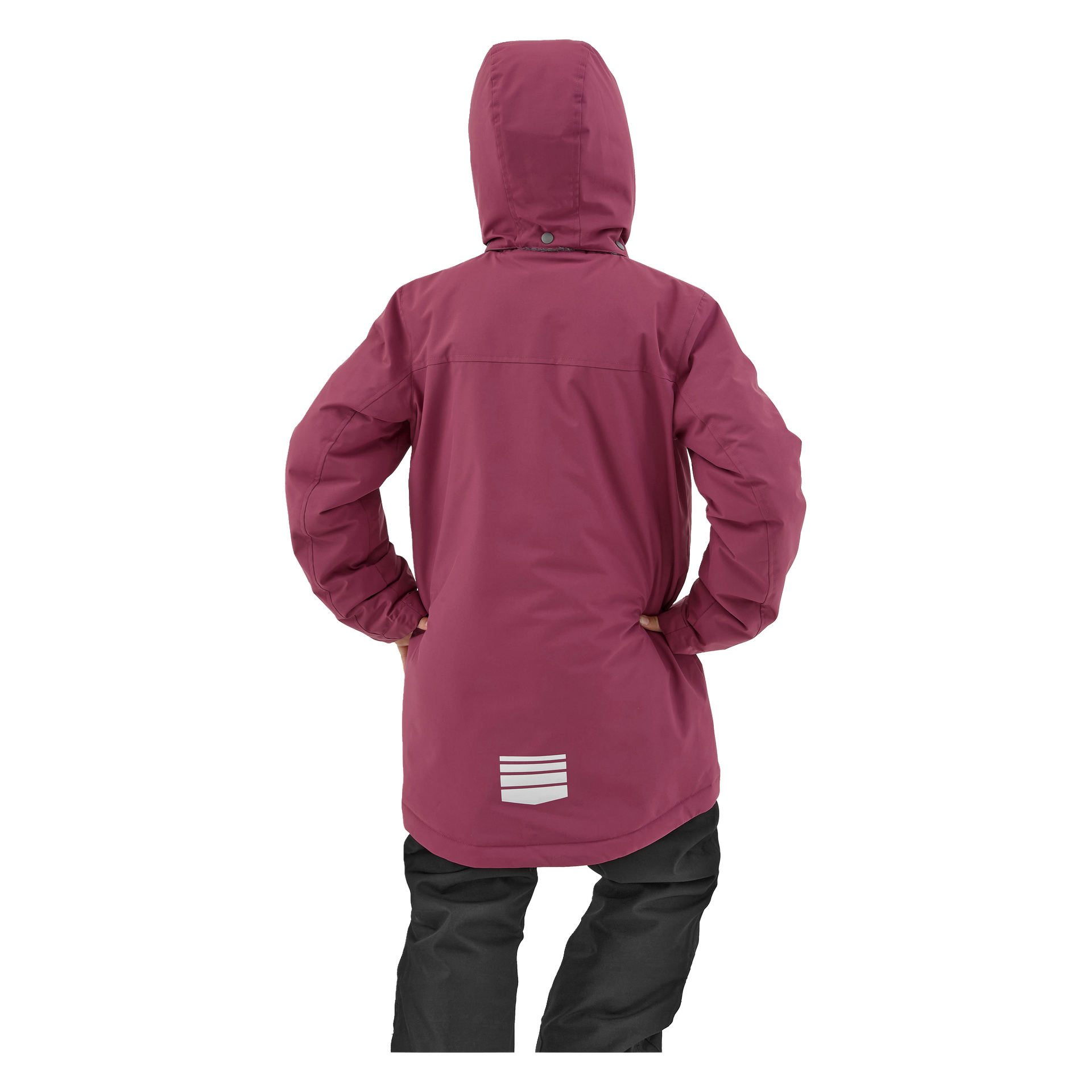 Ett barn klädt i Kayoba Outdoor Kläppen-vinterjackan—en lång, huva med vinröd rock och reflekterande accent nära fållen—står med händerna på höfterna och bär svarta byxor, vända bort från betraktaren.