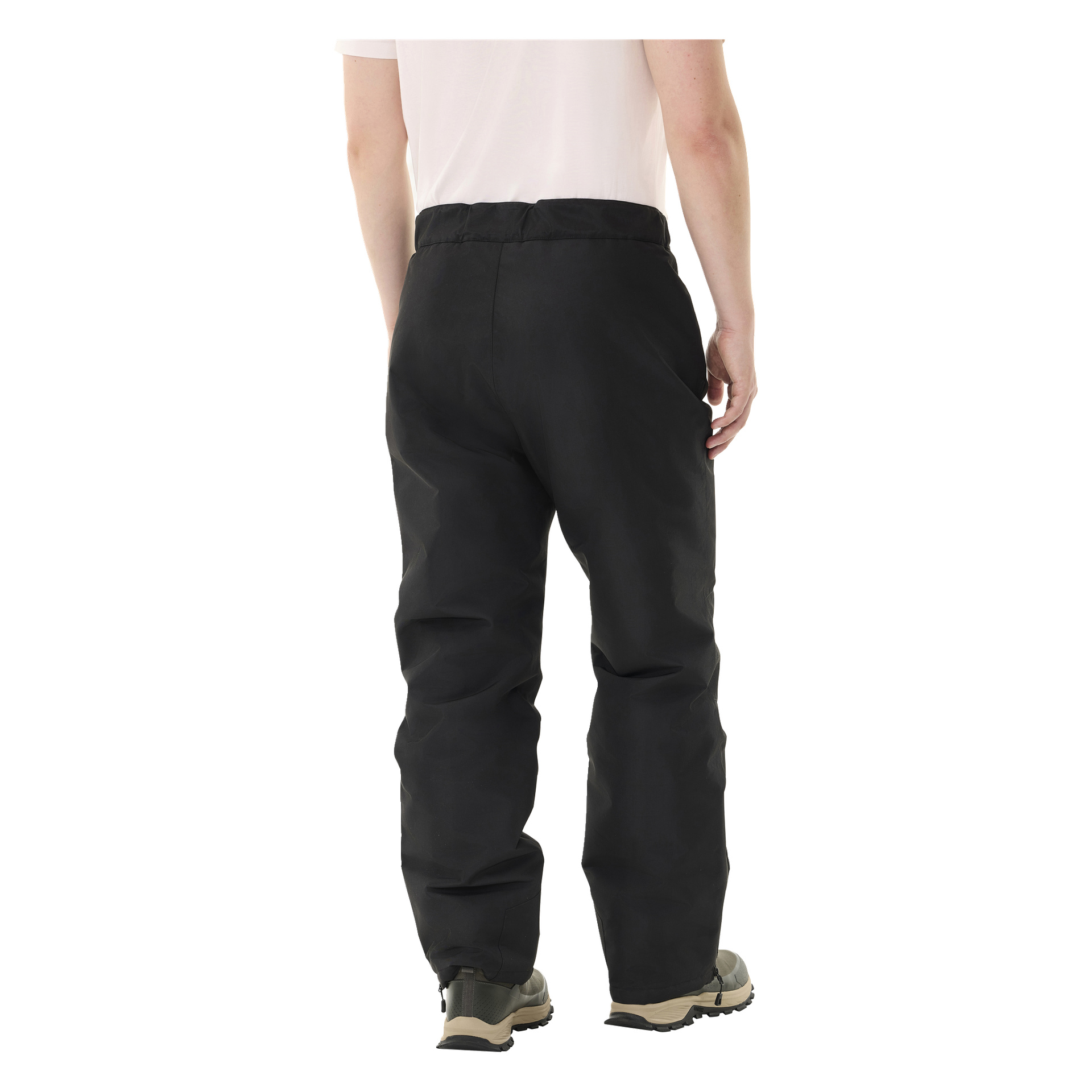Eine Person steht mit dem Rücken zur Kamera, trägt ein hellrosa Kurzärmelhemd, schwarze Kayoba Outdoor Kiruna 2.0 gepolsterte Hosen für Männer und graue Turnschuhe, die die Rückansicht ihres Outfits zeigen.