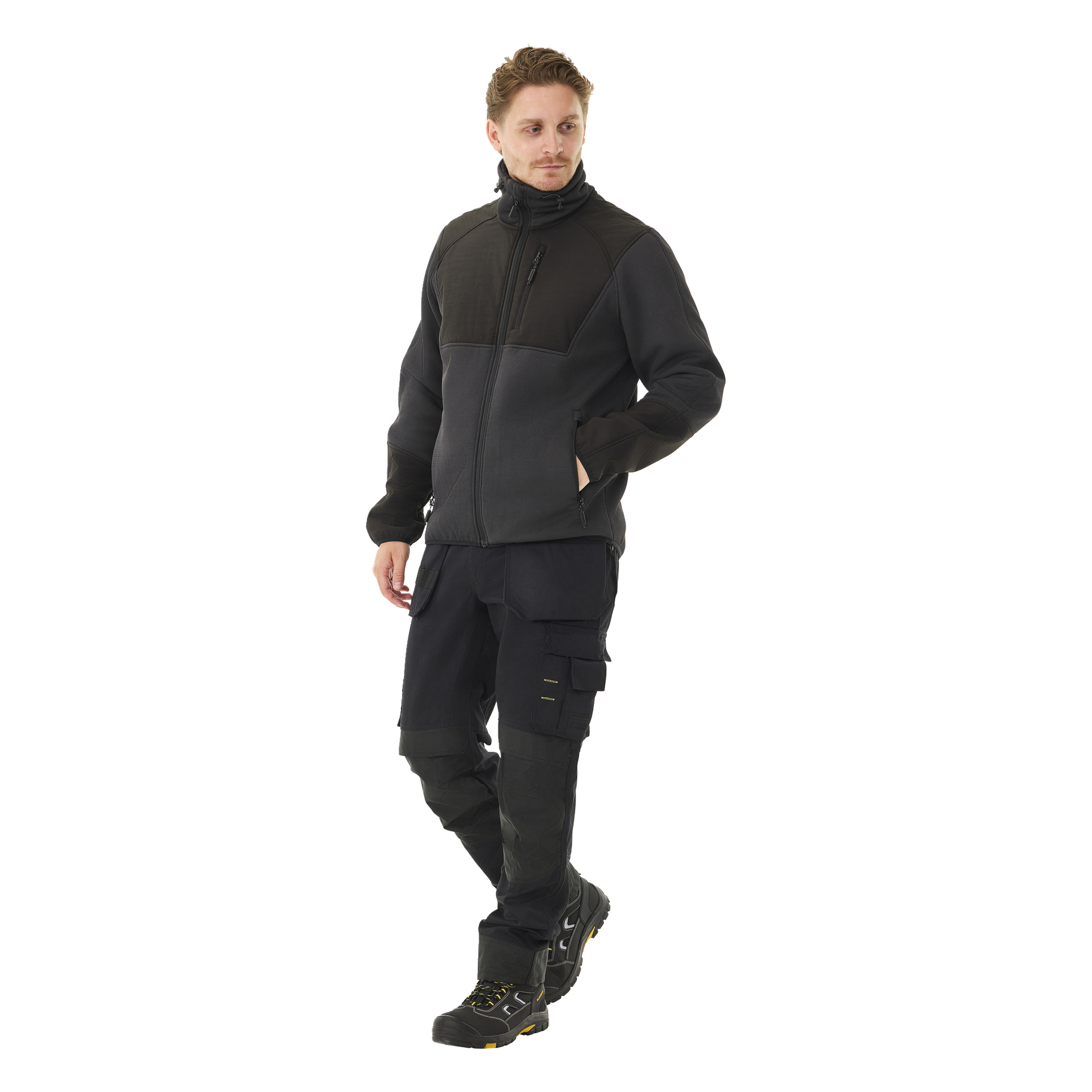 En mann modellerer Bluewear Men's Morten-fleecejakke med bunke i svart, kombinert med svarte cargobukser med flere lommer og svarte arbeidssko med gule detaljer. Han putter nonchalant en hånd i lommen og ser til siden.