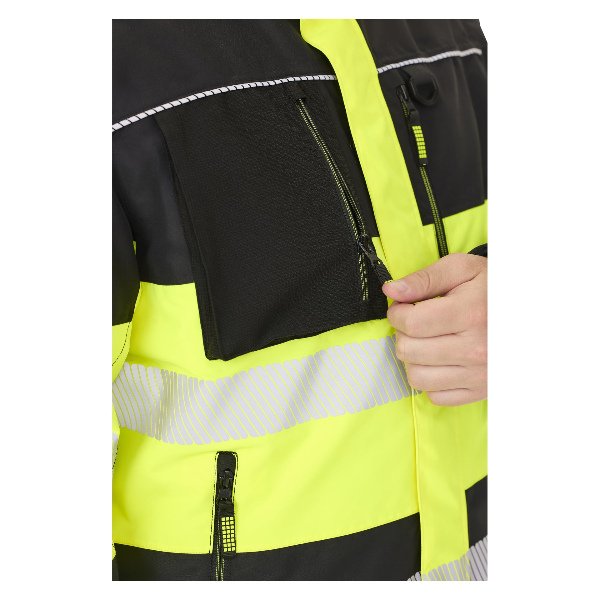 En hånd sees som åpner glidelåsen på brystlommen på en Bluewear Padded hi-vis Lawson-jakke i knallgult og svart med reflekterende striper, som kun viser overkroppen og hånden.