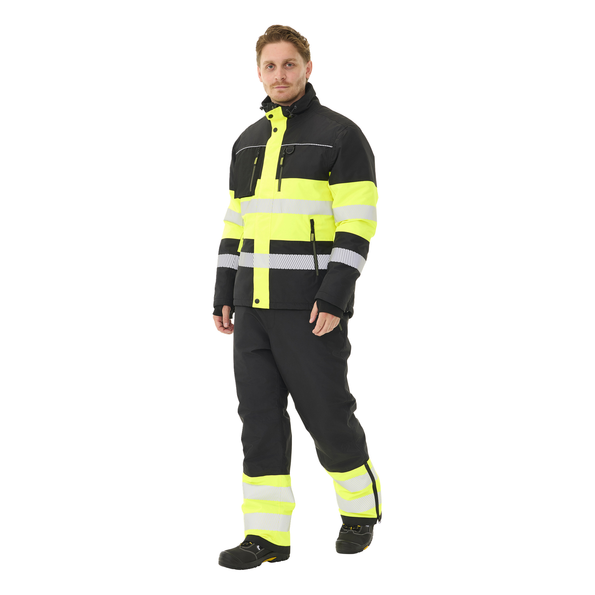 Man har på seg Bluewear Padded hi-vis-jakke Lawson i svart og neongult med reflekterende striper, kombinert med matchende høy-synlige bukser og svarte sko.