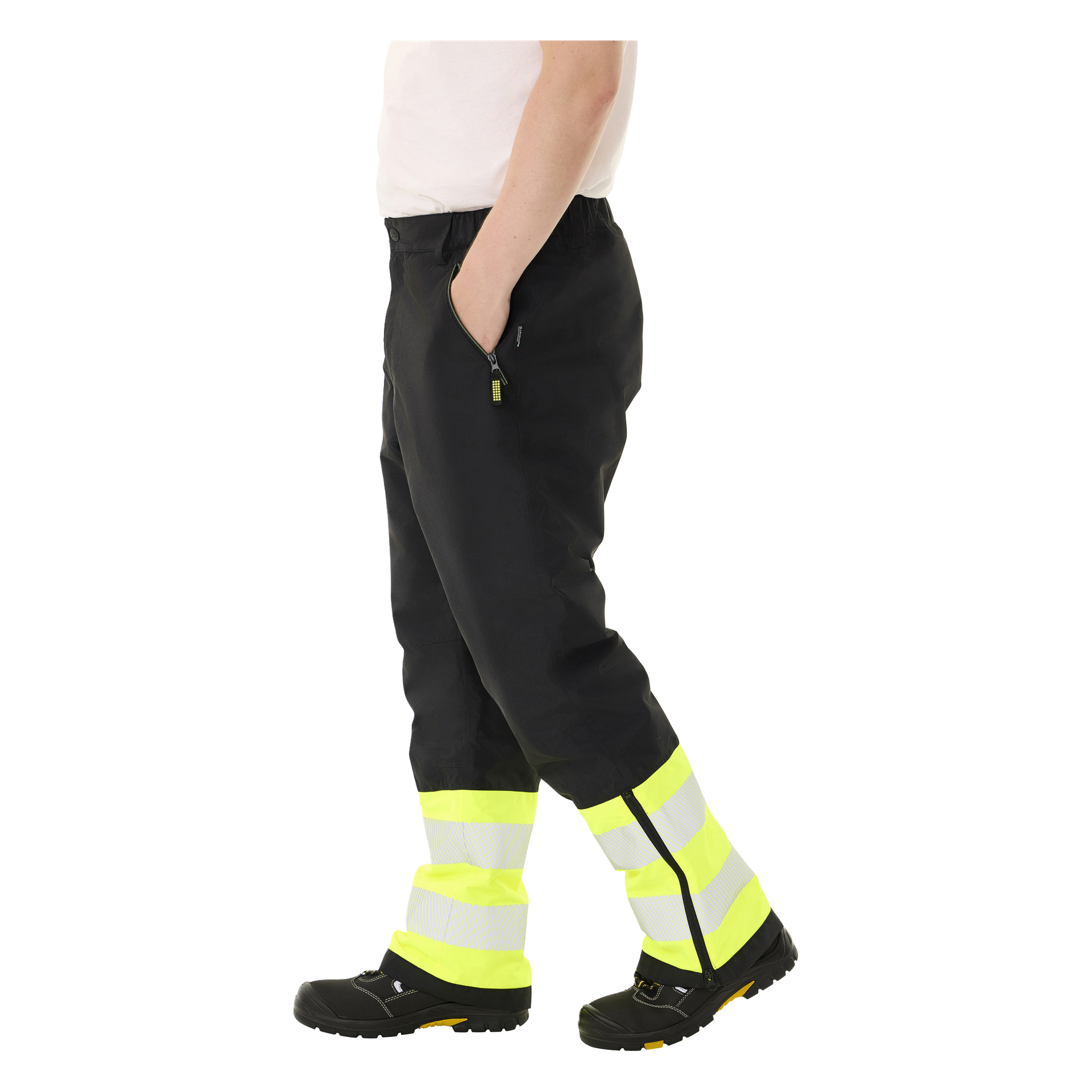 Henkilö käyttää Bluewear Padded -näkyviä Lawson-housuja, mustia keltaisilla heijastavilla raidoilla ja mustia turvakenkiä. Kuvassa näkyy vain alavartalo, toinen käsi lepää taskussa.