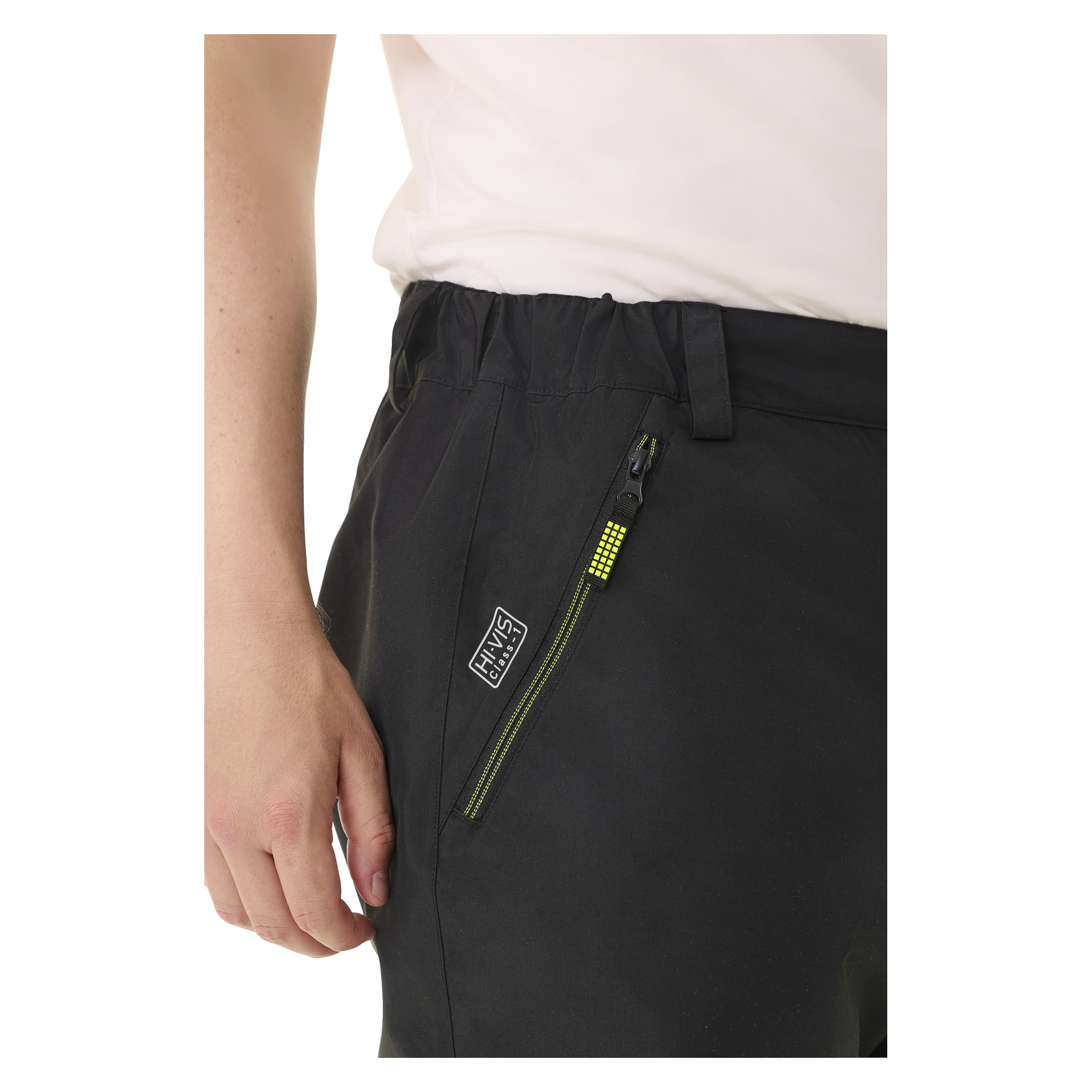 Henkilö esittelee Bluewear Padded -näkyviä Lawson-housuja, jotka ovat pääosin mustat, vetoketjutaskussa, jota korostaa keltainen yksityiskohta ja joissa on pieni HWYS CLUB -logomerkki. Heidän kätensä roikkuu löysästi sivulla, vaaleansävyisen paidan kanssa.