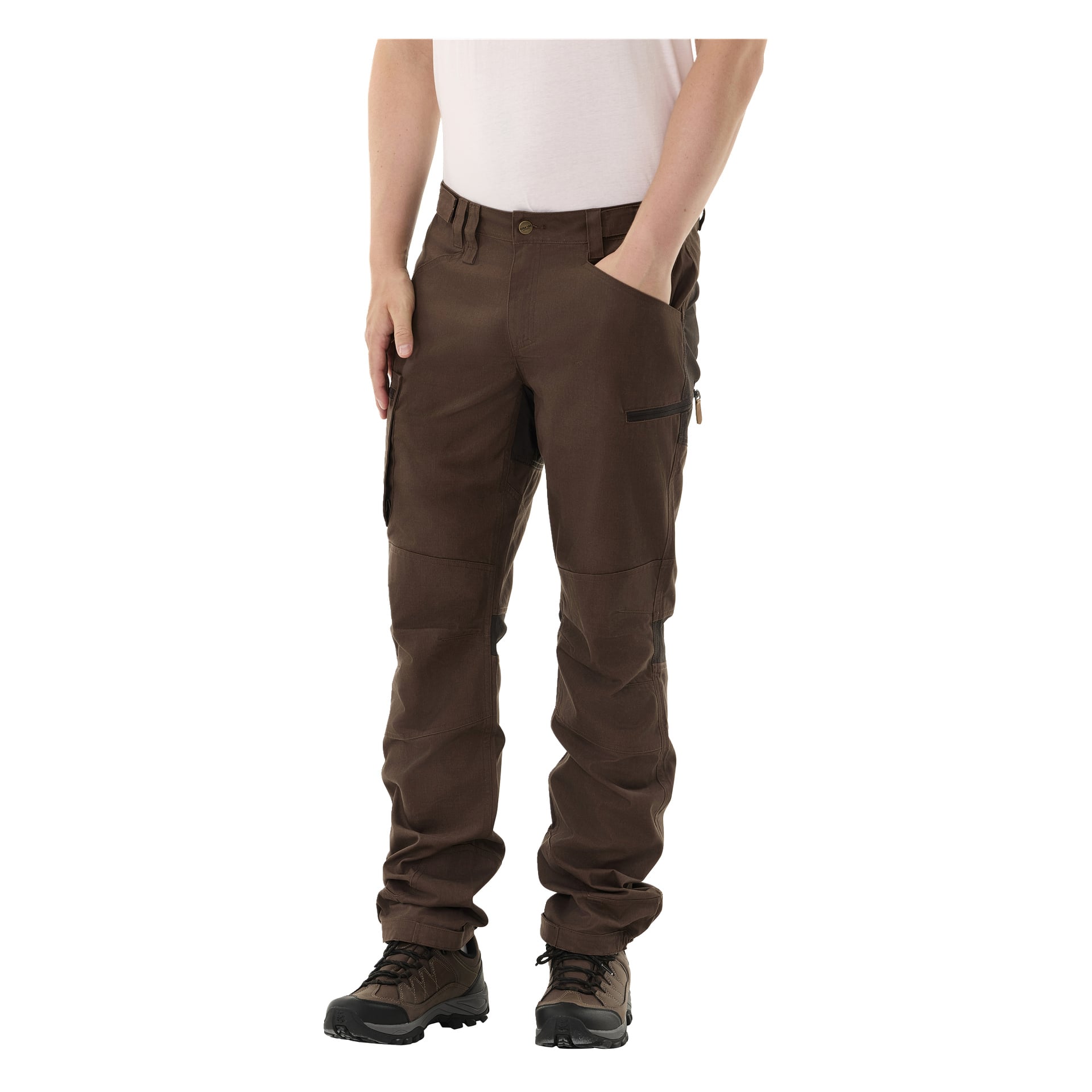 En person klädd i Kayoba Outdoor Men Älvdalen 2.0 utomhusbyxor och en vit skjorta står med ena handen i fickan. Byxorna har flera fickor, och personen bär mörka vandringsskor.