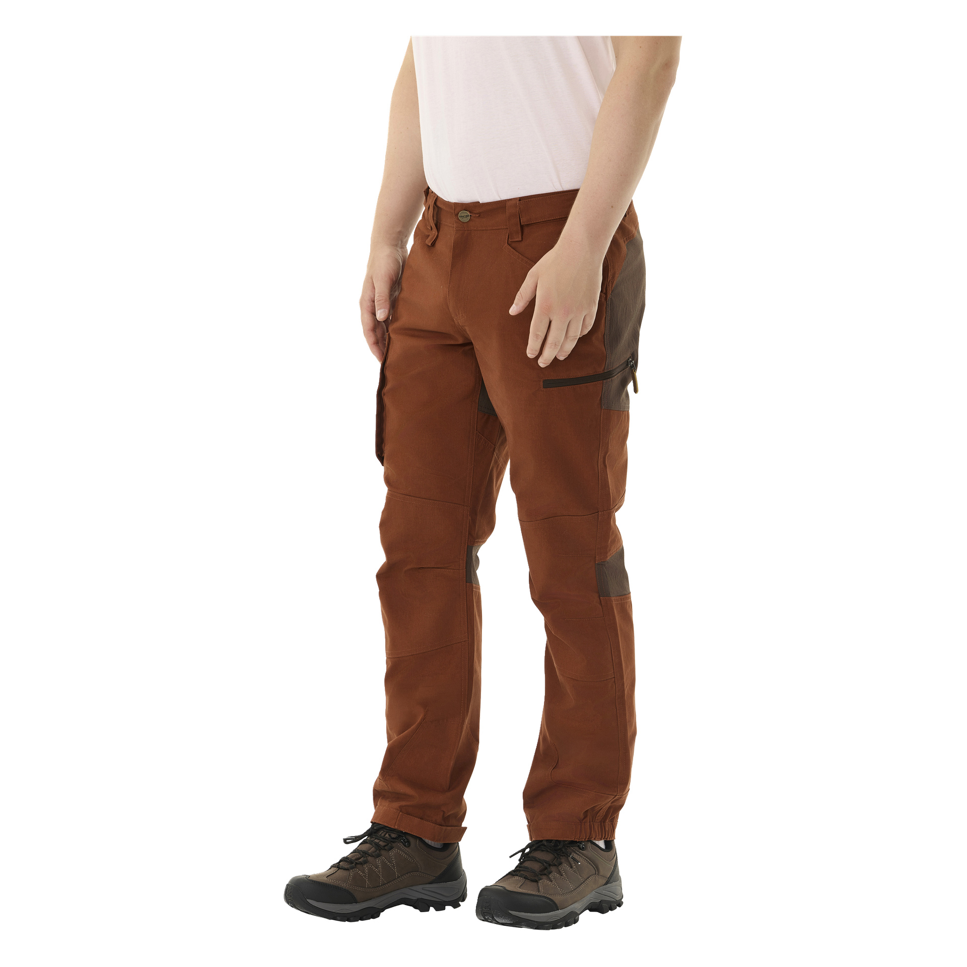 En person er synlig fra livet og ned, kledd i hvit skjorte, brune Kayoba Outdoor Men Älvdalen 2.0 bukser med mørkere paneler, og svarte tursko.