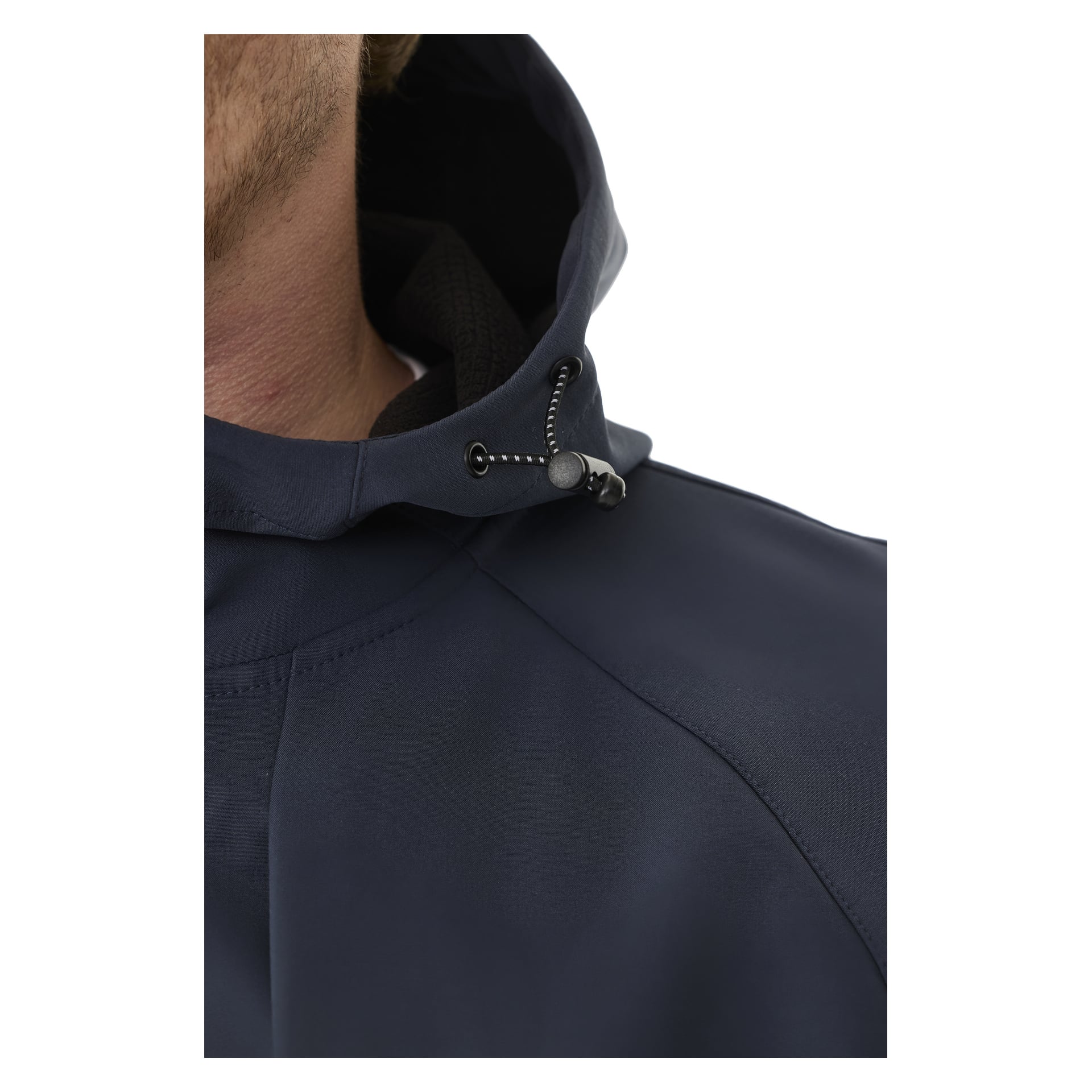 Lähikuva henkilöstä tummansinisessä Kayoba Outdoor Women's Hede -fleecevuorillisessa pehmeäkuorisessa takissa, musta nyöri muovisella kytkimellä. Näkyvissä on vain osa kasvoista ja olkapäästä.