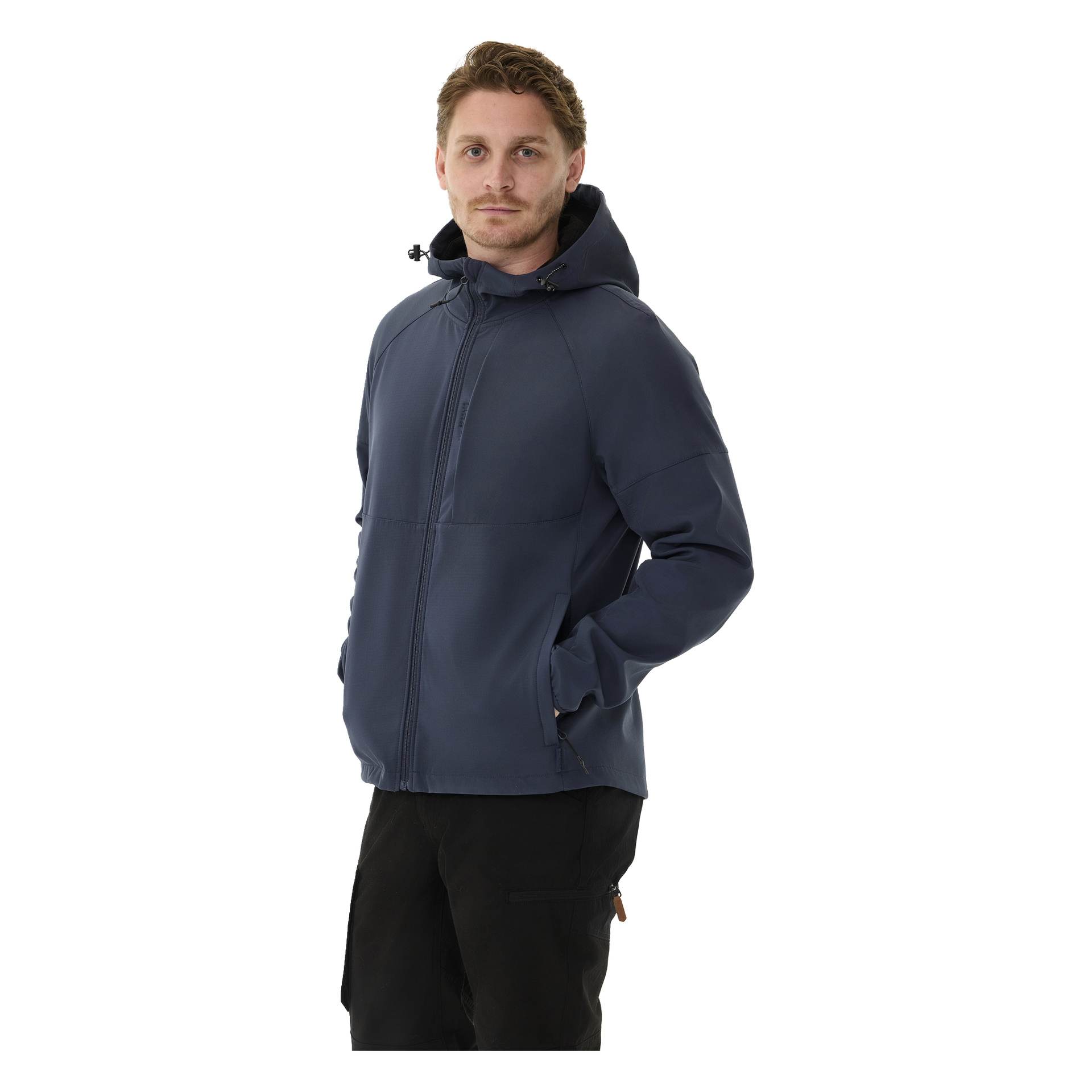 Nainen mallintaa Kayoba Outdoor Women's -fleecevuorattua pehmeäkuorista takkia Hede, tummansinistä huppullista vetoketjua, mustien housujen kanssa ja vasemman kätensä taskussa.