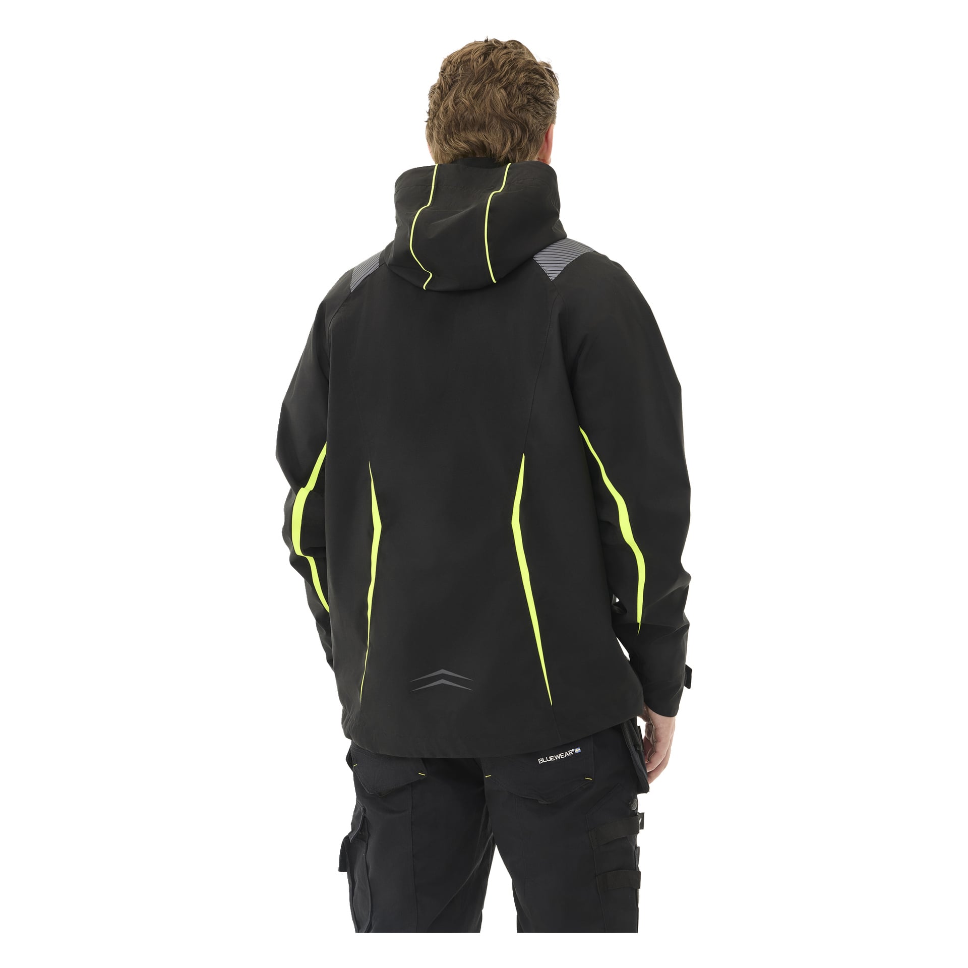 Bilden visar en bakifrån bild av en person klädd i Bluewear Men's stretchjacka Richard, som är svart med gula detaljer och reflekterande drag på axlar och nedre delen av ryggen, kompletterad av svarta byxor.