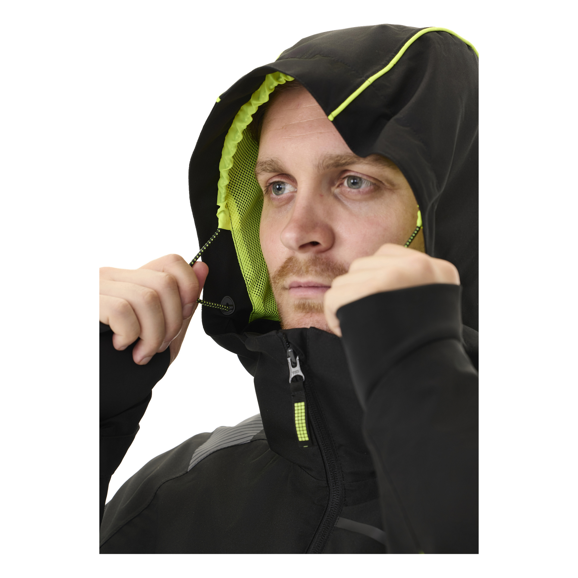 Någon justerar huvdragsnören på en Bluewear herrjacka med stretchskal, Richard, som är svart med neongröna detaljer. Den helt dragkedjade jackan visar sin dragkedja och meshfoder inuti huvan.