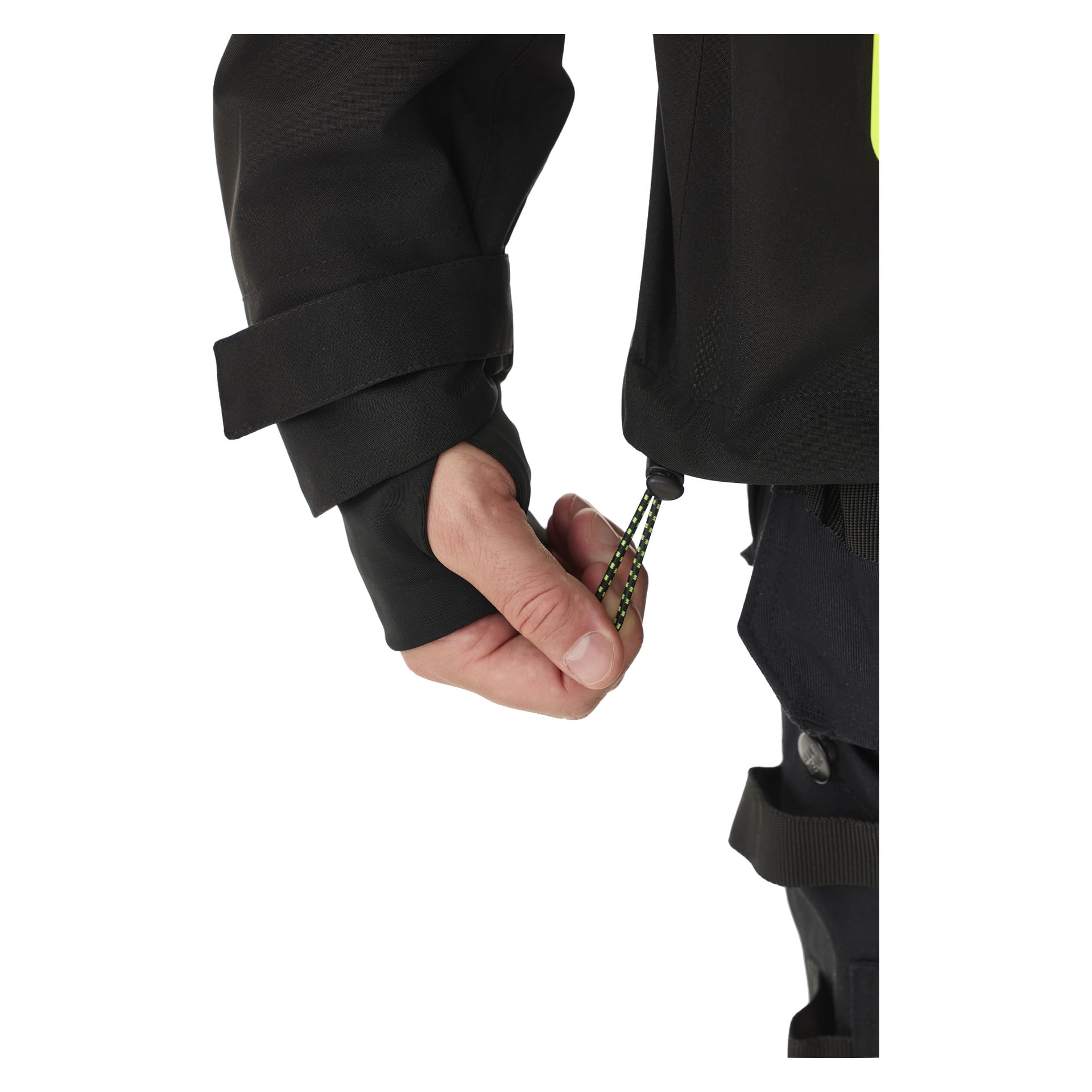 Någon drar i en grön och svart bungee-lina fäst i fållen på en Bluewear herrjacka med stretchshell, Richard. Deras hand är delvis lindad med en tumslinga på ärmen på den svarta jackan.