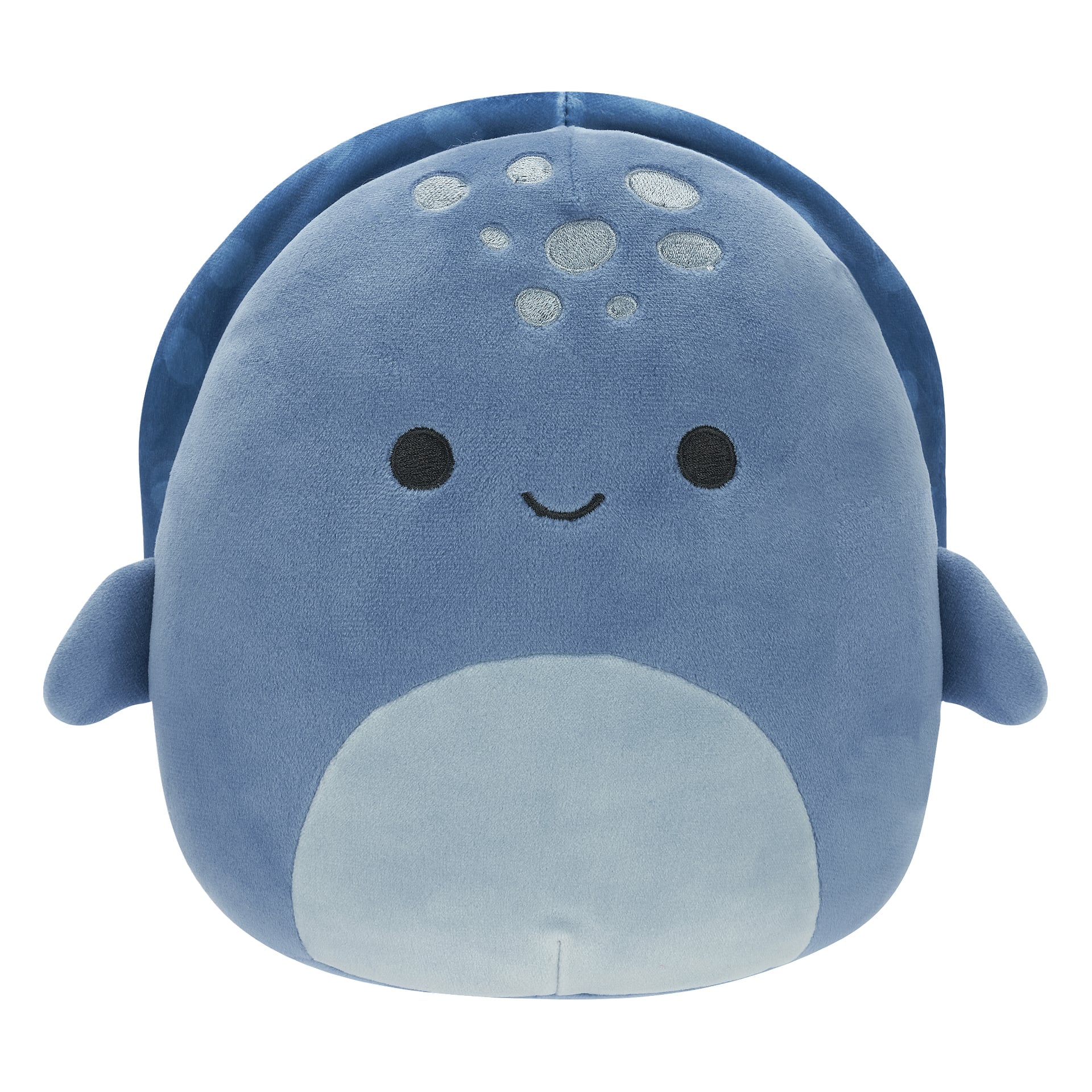 En blå plysjhvalhai Squishmallow, laget av supermykt materiale, har små finner, en blekblå mage, mørke runde øyne, et vennlig smil og lyse flekker spredt over pannen.