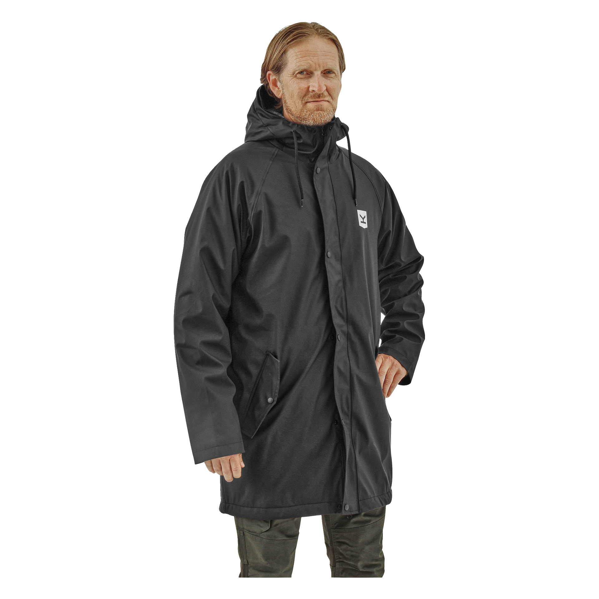 Eine Person schaut nach vorne mit einer Hand auf der Hüfte und trägt die schwarze Kayoba Outdoor Men's Fleece-Regenjacke Visby. Der Kapuzenmantel enthält Druckknöpfe, mehrere Taschen und ein kleines weißes Logo auf der Brust.