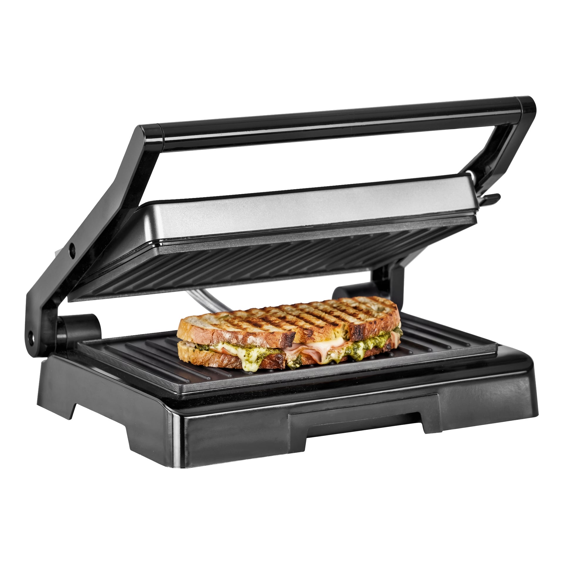 En delvis öppen svart och silverfärgad OBH Nordica-smörgåsgrill avslöjar en rostad smörgås inuti, som visar tydliga lager av bröd, smält ost och grön pesto. Smörgåsen visar framträdande grilllinjer över ytan.