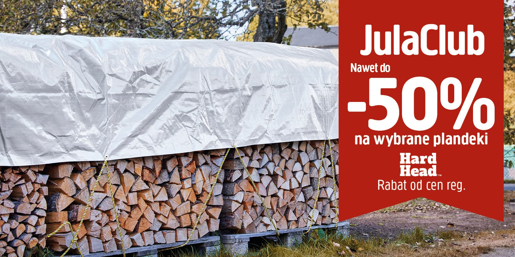Stos drewna opałowego przykryty srebrną plandeką z napisami: JulaClub, Nawet do -50% na wybrane plandeki, Hard Head oraz Rabat od cen regulaminowych.