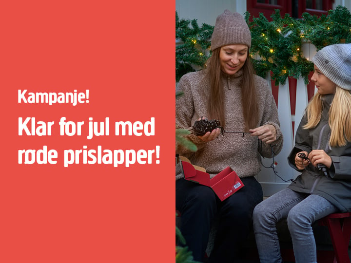 To personer sitter ute blant festlig grønt, med julelys og en kongle i hendene. Til venstre står det på rød bakgrunn: Kampanje! Klar for jul med røde prislapper!.