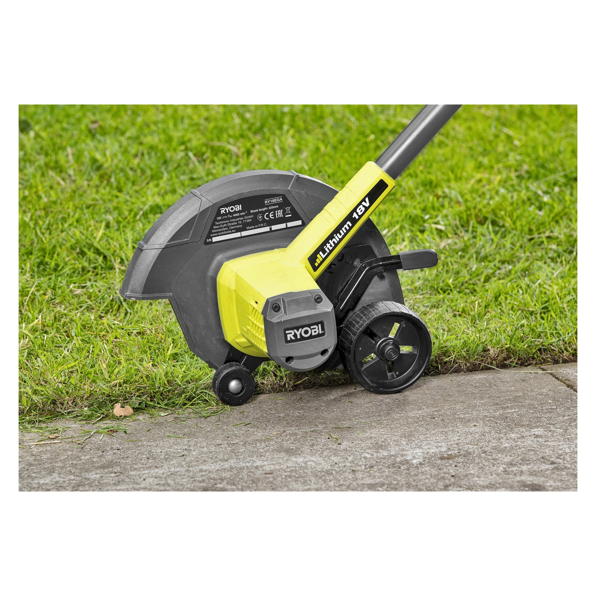 En Ryobi One+ Edge Trimmer RY18EGA-0, drevet av et 18V litiumbatteri, klipper gress pent langs kanten av et betongfortau, noe som resulterer i en skarp avstand mellom plenen og fortauet.