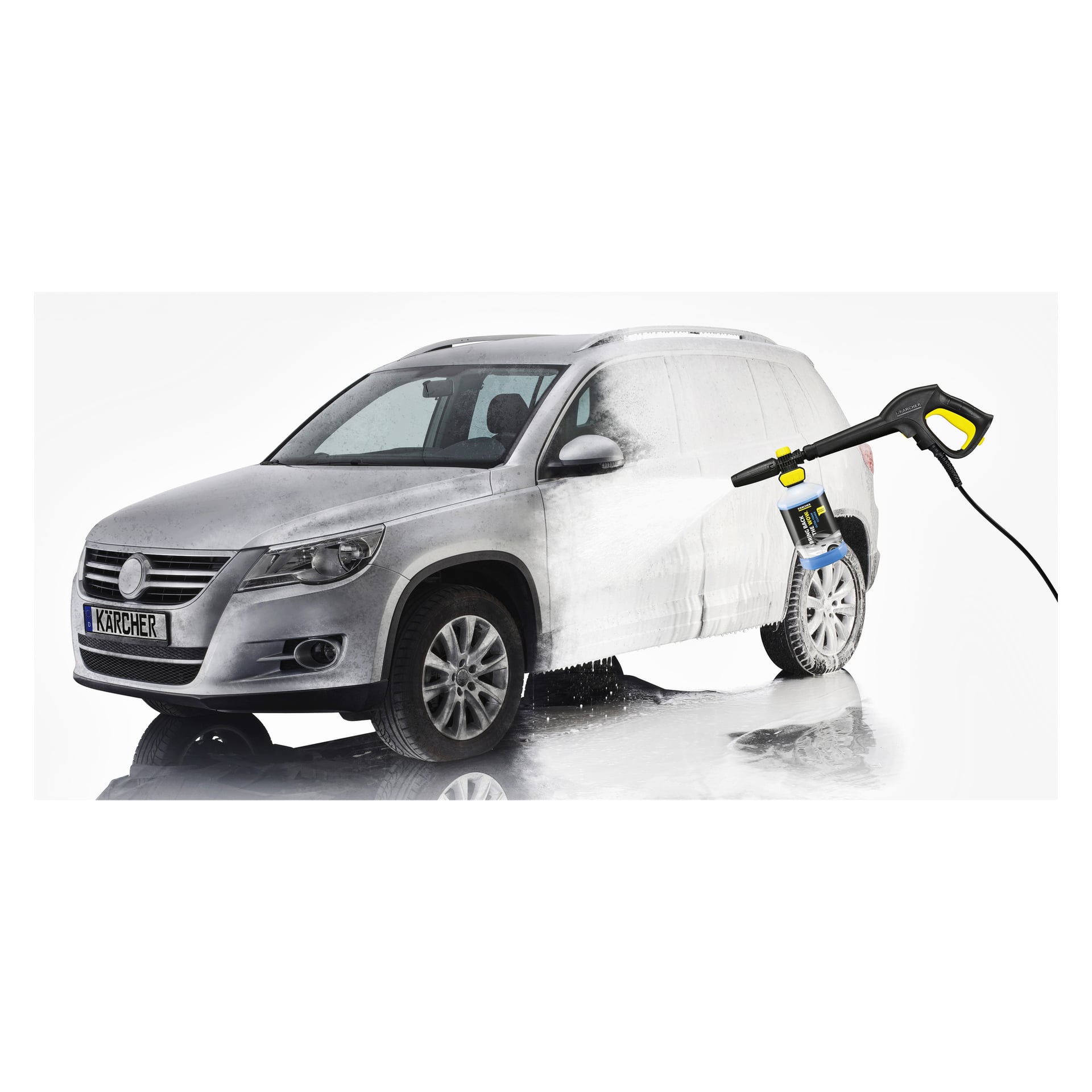 En silverfärgad SUV är sprayad med skum med Kärcher Car schampo 3-i-1 Formula, Plug 'n' Clean. Skum täcker delar av bilen och det finns reflektioner på golvet.