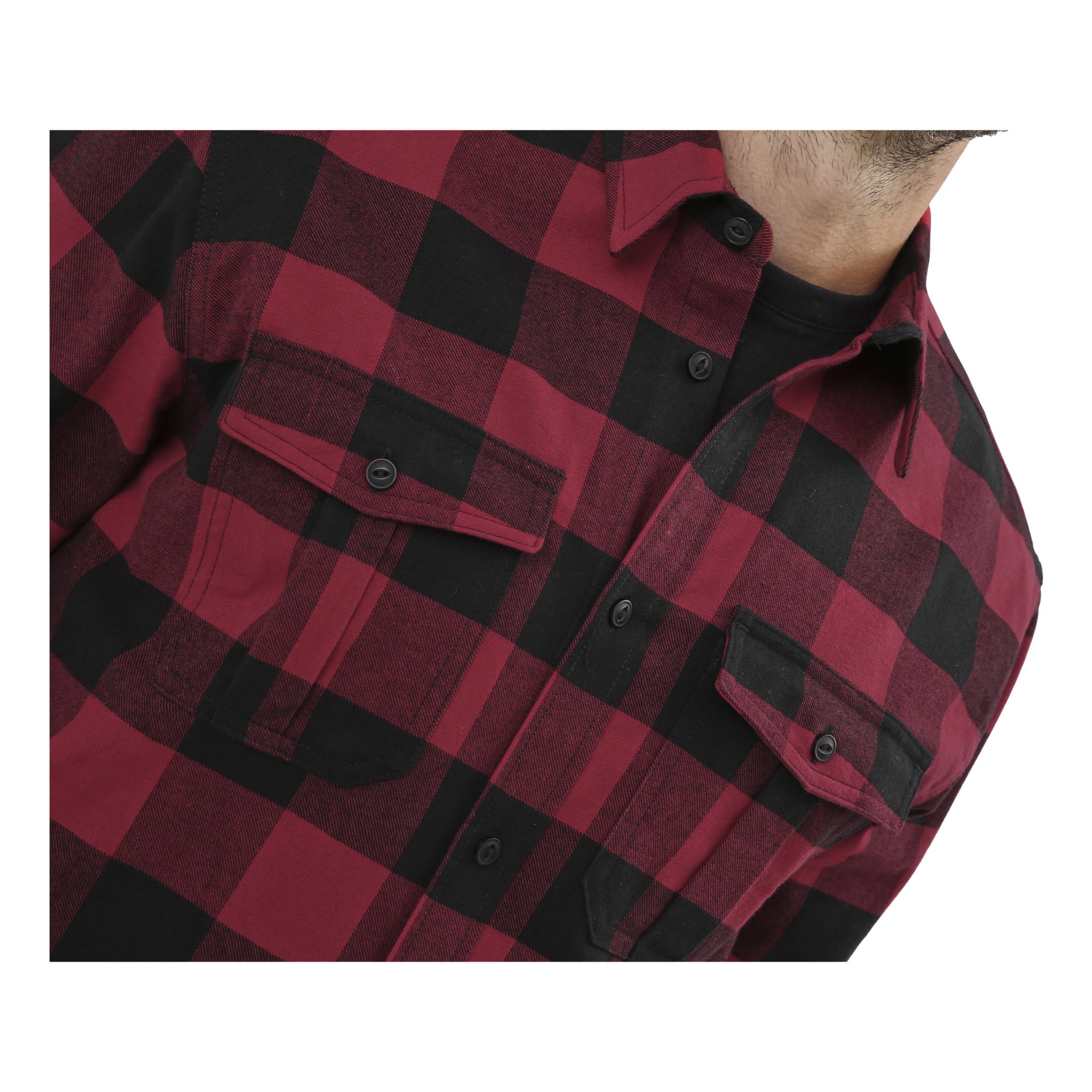 En person vises fra overkroppen og opp, iført en Bluewear Men's flanellskjorte i rød og svart rutete med to knapperte brystlommer, over en svart undertrøye. Bare en del av haken er synlig.