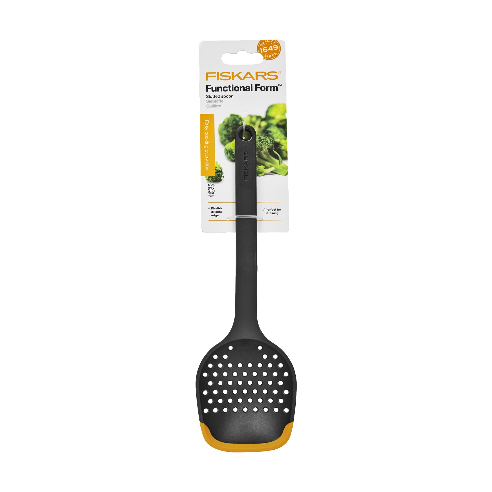 En svart perforerad slev från Fiskars Functional Form med orange detaljer visas i förpackningen, som visar produktdetaljer och en bild på broccoli i bakgrunden. Handtaget har ett hänghål i änden.