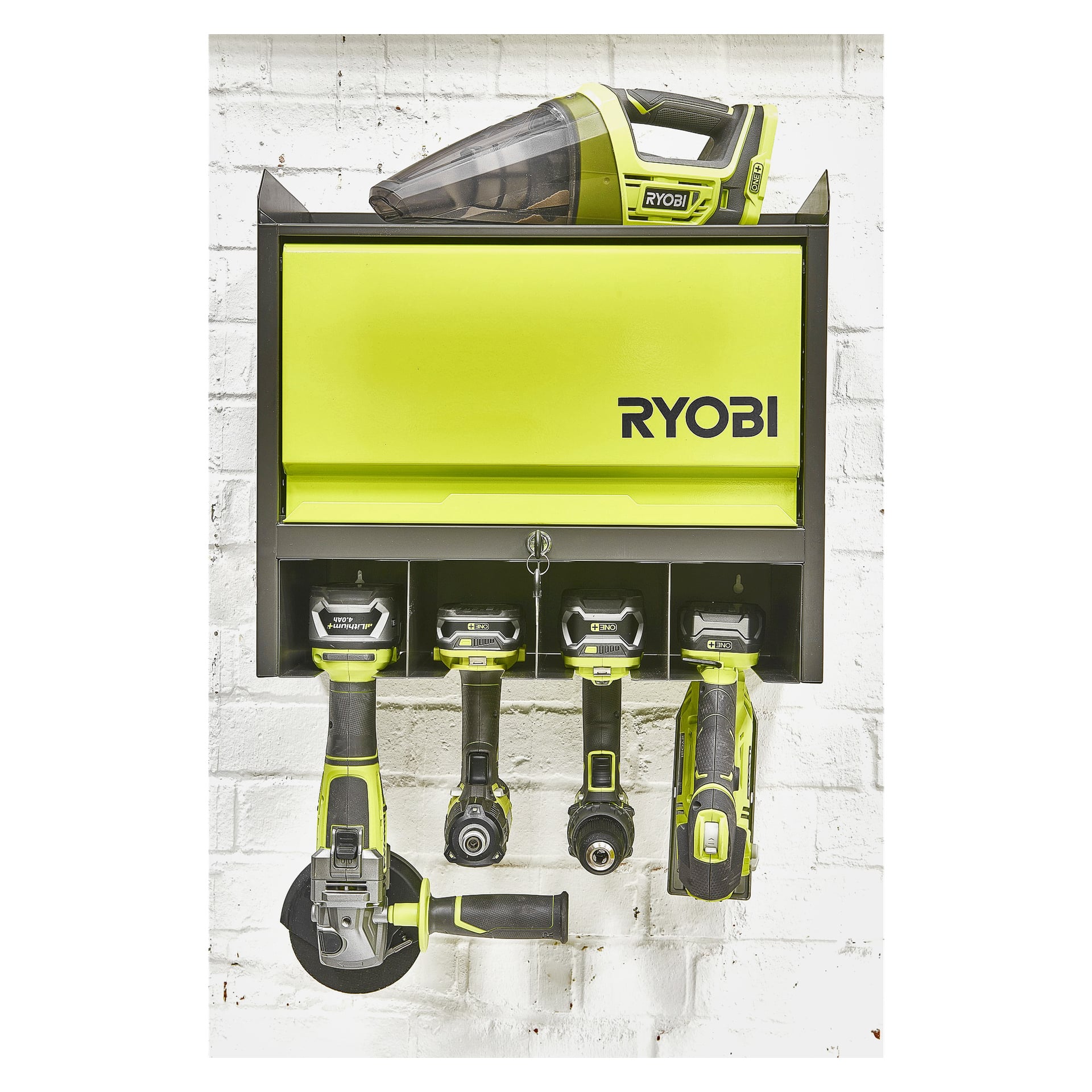 Ett väggmonterat Ryobi-skåp rymmer en handhållen dammsugare, tre batterier till elverktyg, en vinkelslipmaskin, en borr och en slagskruvdragare.