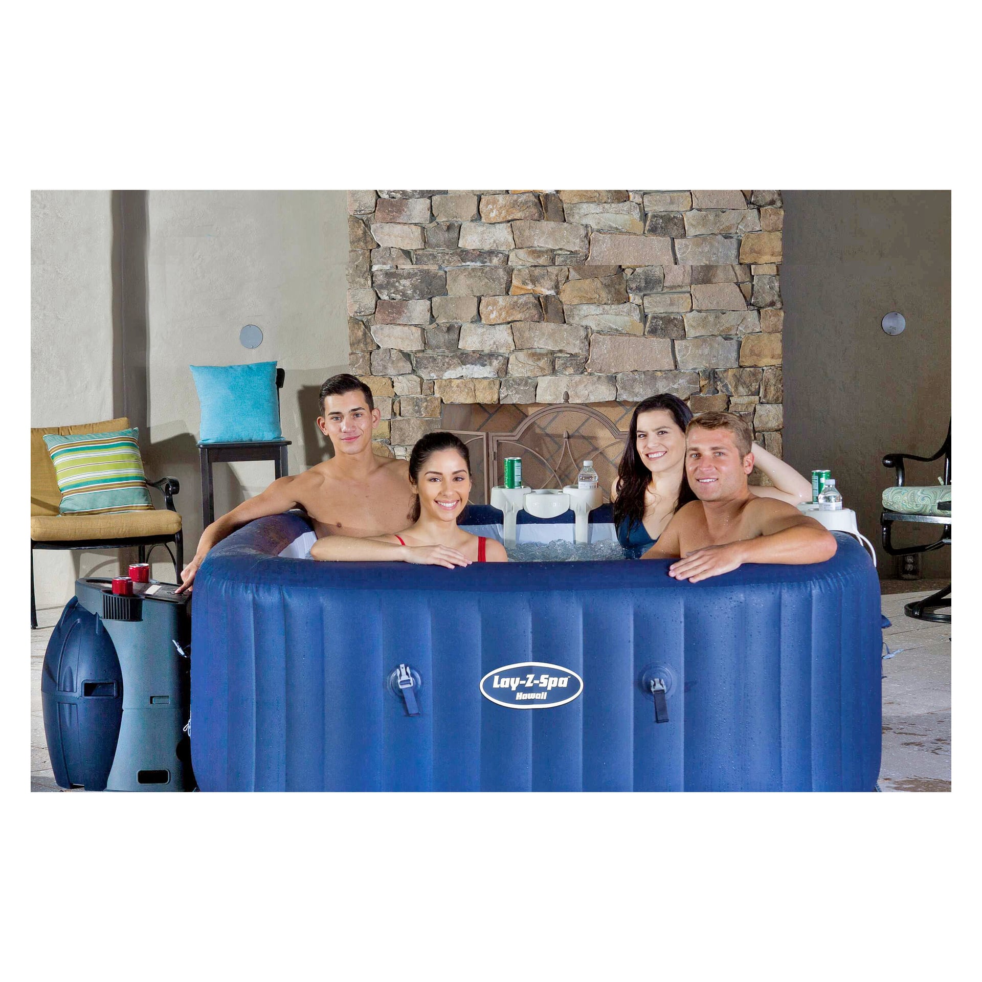 Vier Erwachsene entspannen sich in einem Spa-Bad und grinsen die Kamera an, während ihre Getränke auf dem Getränkehalter für das Spa-Bad von Bestway stehen. Hinter ihnen sind ein steinerner Kamin und Terrassensitze sichtbar.