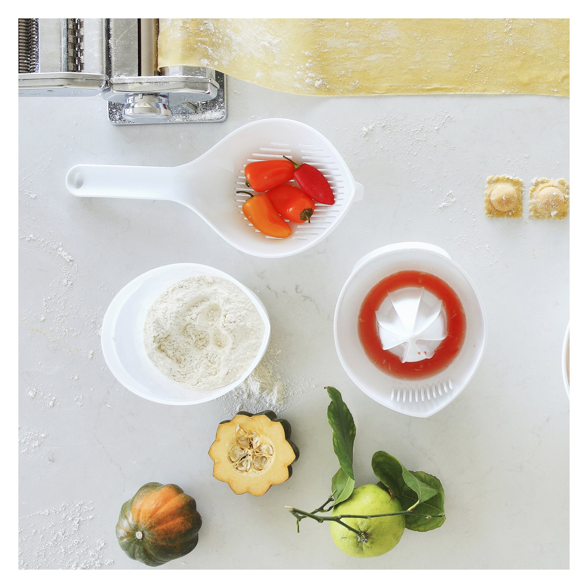 Menuett-silanden finns med rullad deg, ravioli, mjölskålar, små tomater, en citrusjuicer med juice och en blandning av squash och citrusfrukt.