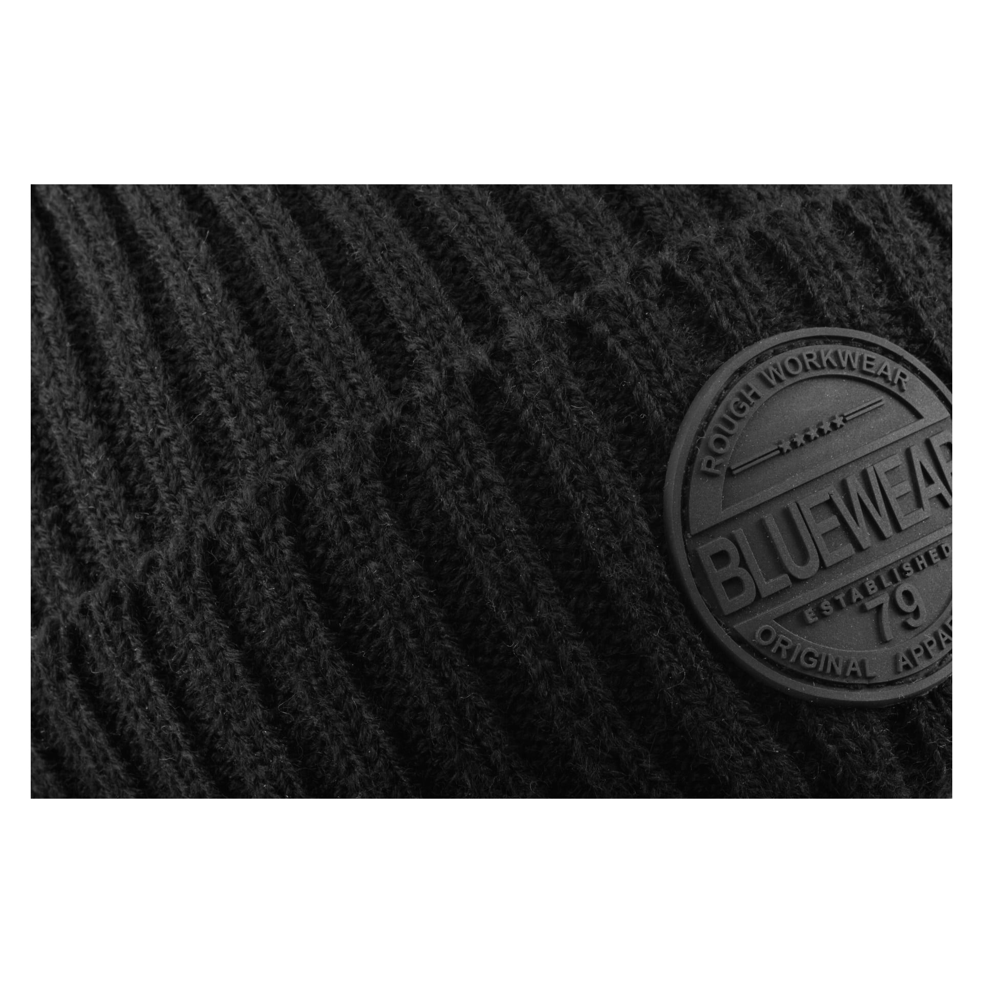 Zbliżenie na prążkowaną czarną dzianinową czapkę Bluewear z okrągłą naszywką z przodu, na której widnieje napis "BLUEWEAR 79 ROUGH WORKWEAR ORIGINAL APPAREL ESTABLISHED."