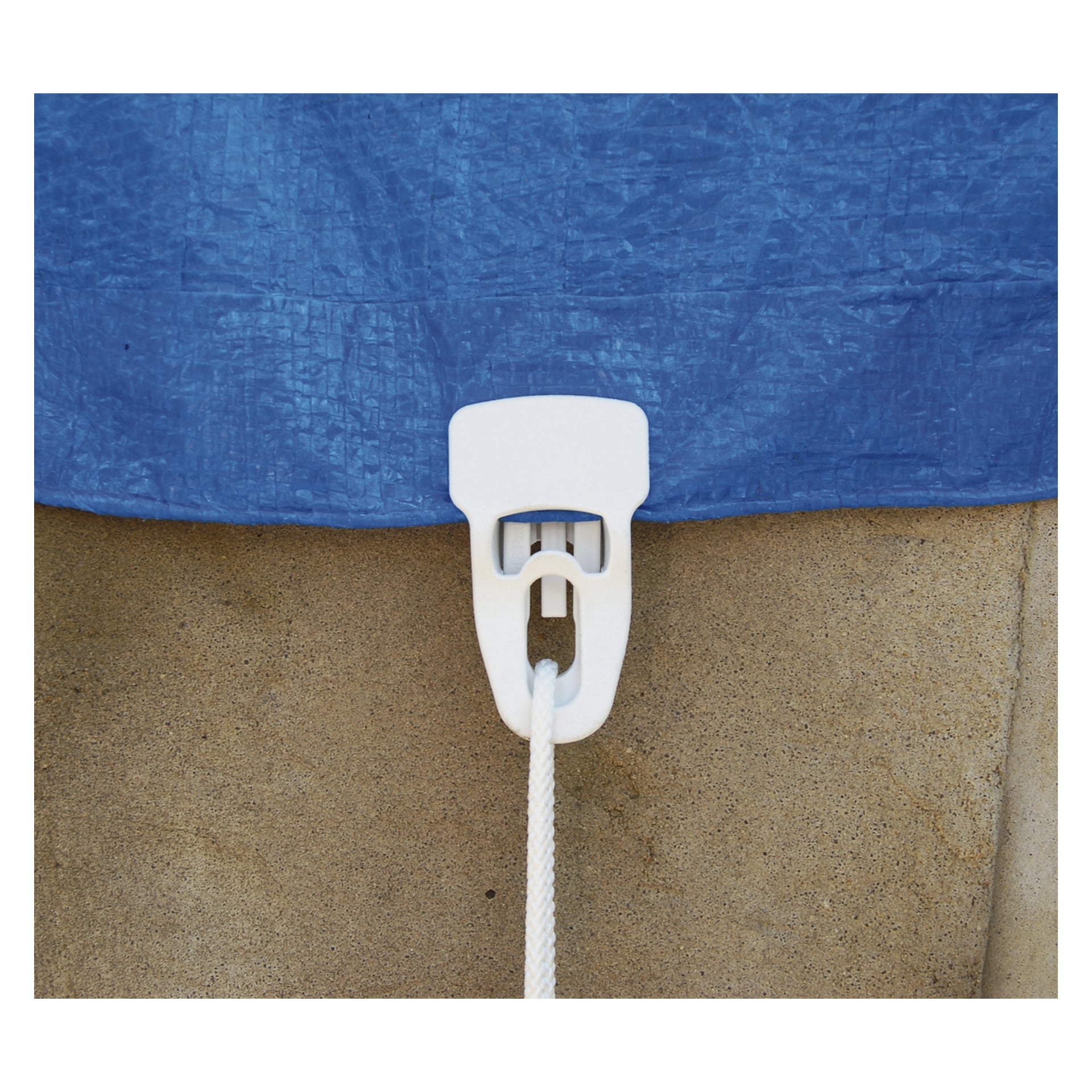 En vit plast Holdon Systems Multi-clamp från en fyrpack fäster en blå presenning på en beige betongyta. Ett vitt rep passerar genom klämman och spänner presenningen tätt över den övre halvan av bilden.