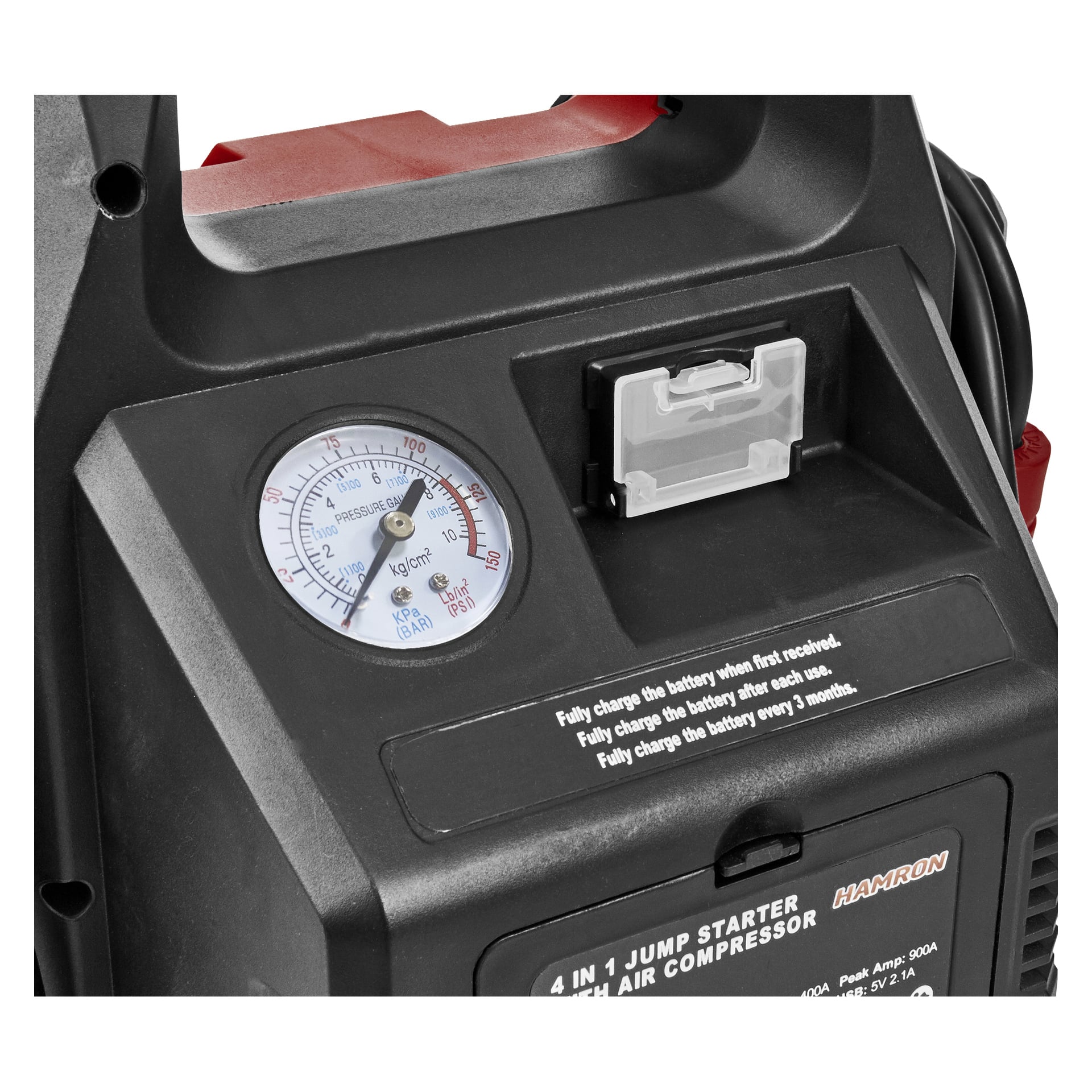 Nærbilde av den svarte Hamron Jump Starter 4-i-1, med trykkmåler, gjennomsiktig rom og trykte instruksjoner som leser Lad batteriet fullt ut på kvitteringen og hver tredje måned.