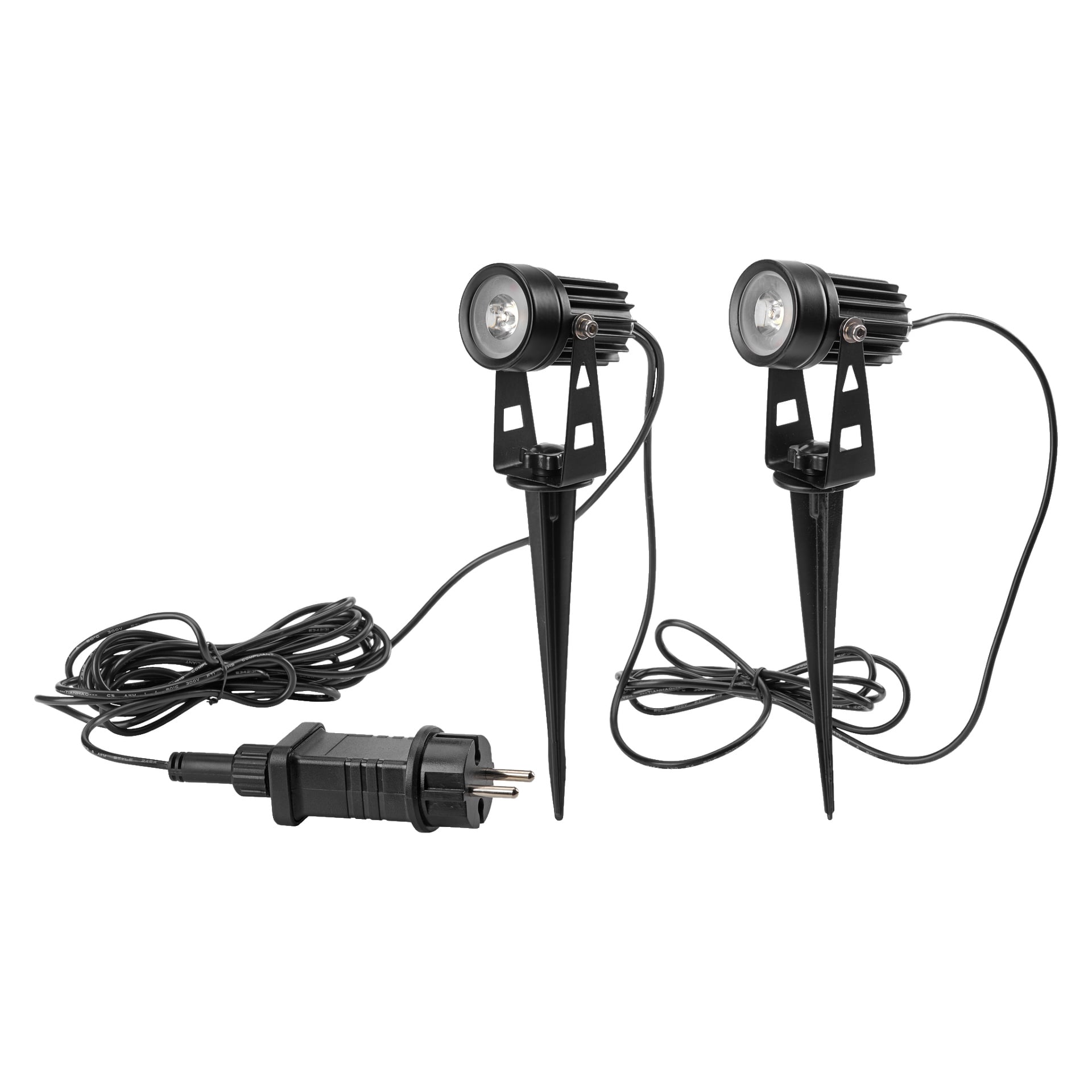 Pokazane są dwa czarne reflektory LED z pakietu Anslut 2-pack, każdy z ostrym uziemieniem i podłączonym kablem zasilającym kończącym się wtyczką. Lampy stoją pionowo na swoich palikach, zaprojektowane do prostego montażu na zewnątrz.