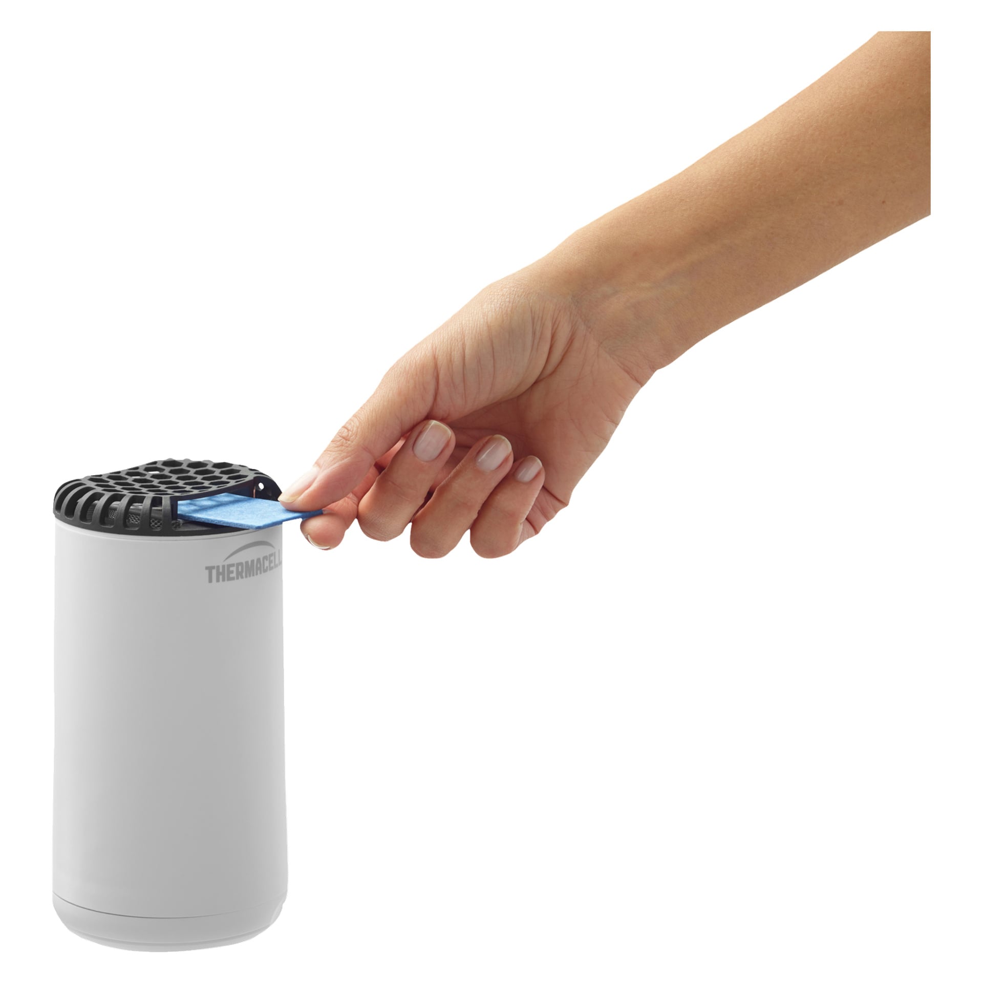 En hand placerar en blå rektangulär platta i toppen av en vit cylindrisk Thermacell Mosquito Protection Mini Halo med ett svart galler. Enheten är märkt THERMACELL.