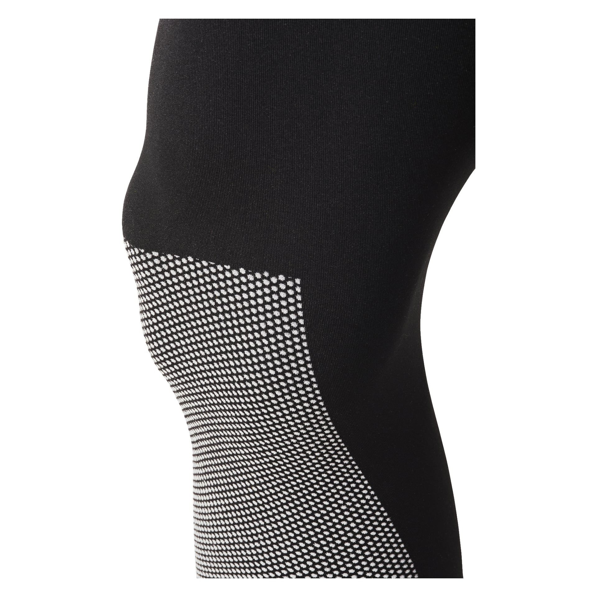 En närbild visar en persons knä och övre vad klädd i svarta Bluewear Pro Workwear Base Layer 2 Pieces, utmärkta av ett vitt prickigt mönster längs ena sidan. Fokus ligger på tygets textur och stilfulla design.