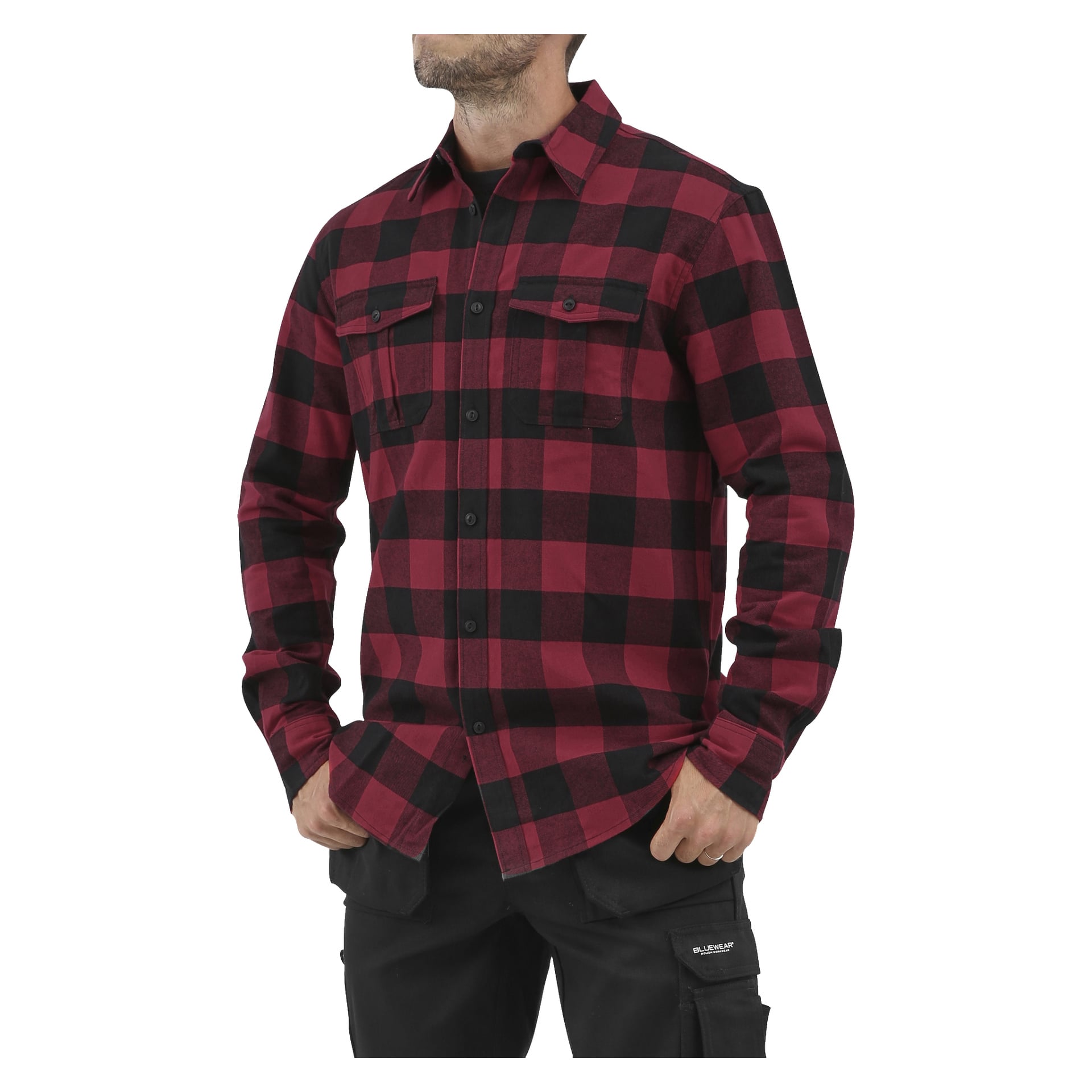 Osoba ubrana w flanelową koszulę Bluewear Men's z czerwono-czarnym kraciastym wzorem i dwoma kieszeniami na piersi, do tego czarne spodnie; ich twarz jest częściowo zasłonięta.