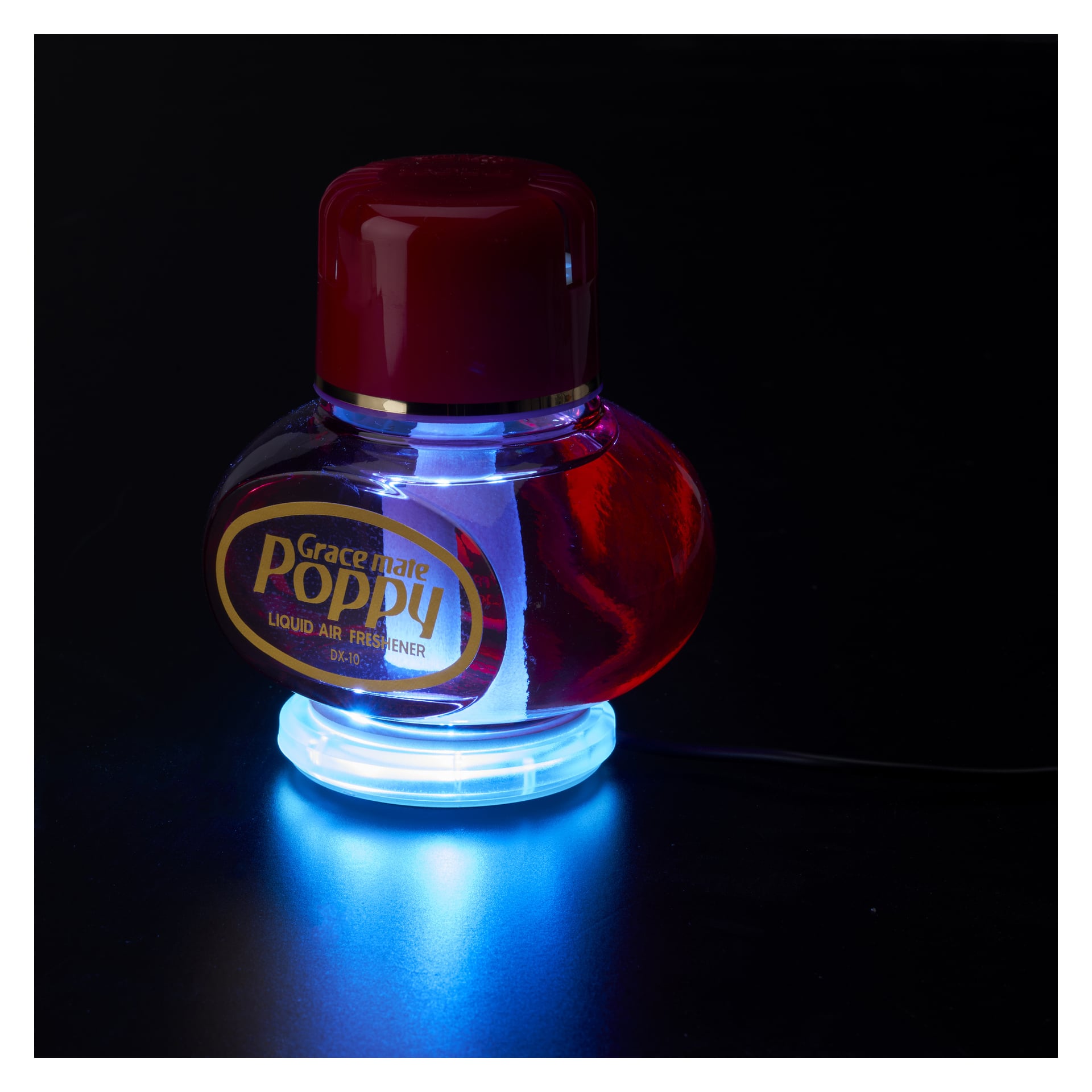 En rund Grace Mate Poppy flytande luftfräschare med röd lock sitter ovanpå en Hamron LED-platta för Poppy MULTI, som lyser blått underifrån. Frametiketten syns tydligt med flaskan mot en mörk bakgrund.