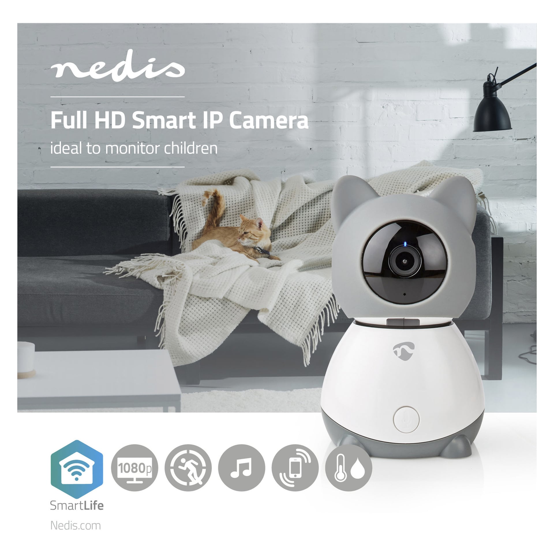 En grå och vit kattformad Nedis SmartLife IP-kamera står på ett bord i ett mysigt vardagsrum, medan en brun tabby-katt slappnar av i soffan bakom den. Bildtexten marknadsför Full HD SmartLife IP-kameran från Nedis som ett utmärkt val för att hålla koll på barn.