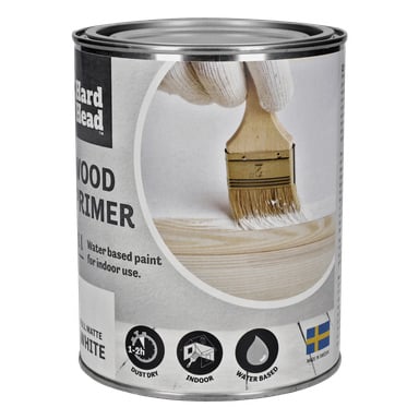 En boks med Hard Head Wood grunning, merket vannbasert hvit innendørs grunning, med et bilde av en hanskebestilt hånd som påfører produktet på treverket, og ikoner for støvtørring, innendørs bruk, vannbasert formel, og laget i Sverige.