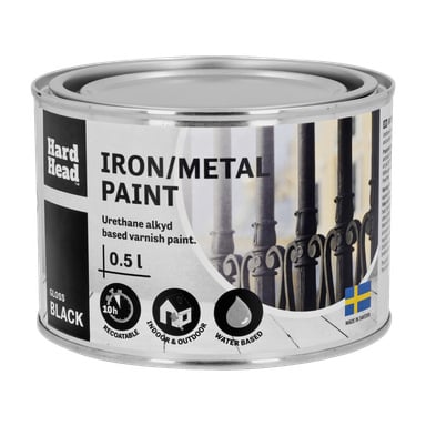 En 0,5 liters burk Hard Head Iron/Metal Paint i glansig svart. Etiketten beskriver den som en vattenbaserad uretanalkydfärg som kan beläggas om, lämplig för inomhus- och utomhusapplikationer, och produceras i Sverige. Förpackningen visar en bild av dekorativt metallarbete.