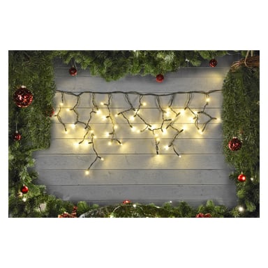 Gröna girlander dekorerade med röda ornament ramar in en grå trävägg, upplyst av EKVIP:s LED-istappssträng Connectable System. De lysande ljusen skapar en varm och festlig julstämning i centrum.
