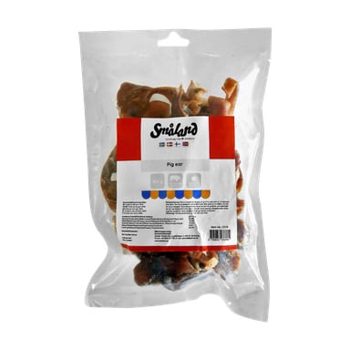 Zapieczętowane plastikowe opakowanie z napisem Småland zawiera smakołyki dla psów, a na froncie widnieją flagi, różne ikony, kod kreskowy oraz szczegóły produktu. Smakołyki są widoczne dzięki przezroczystemu opakowaniu.