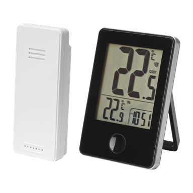 En digital termometer med en stor, lättläst display visar både inomhus- och utomhustemperaturvärden i Celsius. Bredvid den står en separat vit trådlös sensor. Termometern står upprätt och visar tydligt båda temperaturmätningarna.