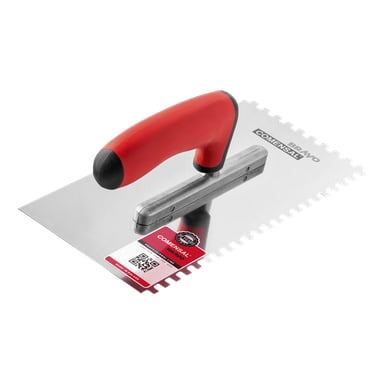 En Comensal kakelspade med ett glänsande, rektangulärt hackat blad och ett tvåfärgat rött och svart handtag. En produktetikett som visar både en QR-kod och streckkod är fäst i det nedre vänstra hörnet av mursleven.