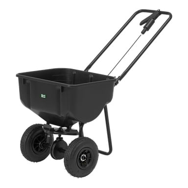 En svart trädgårdsspridare med fyra hjul, en rymlig plastbehållare, hållbar metallram och ett tryckhandtag, lämpligt för att sprida frö, gödsel eller andra gräsmatteprodukter.