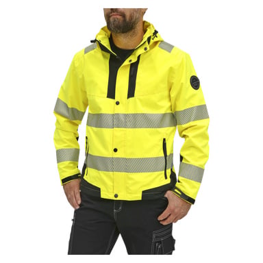 En person bär Bluewear Hi-Vis-jackan, som är klargul med grå reflekterande ränder, svarta dragkedjor och svarta detaljer. Deras händer är nedstoppade i fickorna och bara en del av huvudet är synligt.