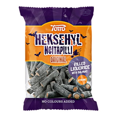 En påse Toms Häxvrål med svarta lakritsgodis och salmiafyllning. Förpackningen har orange, vit och lila färger och framhäver som inga färger till, och godiset är starkt fyllt med lakrits och lax.